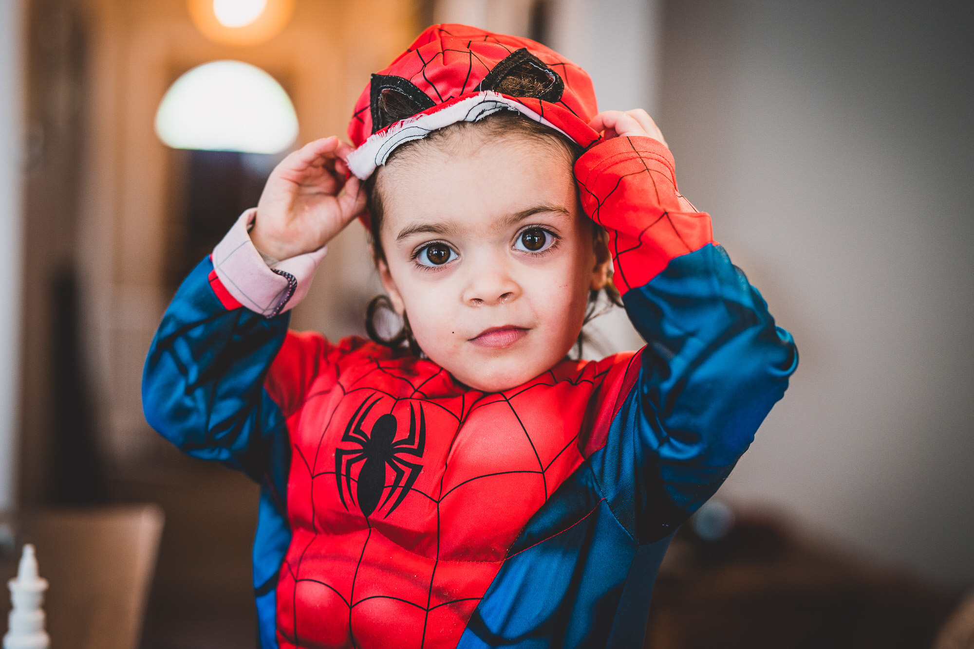 A child posing in a Spider-Man costume for a wedding photo.