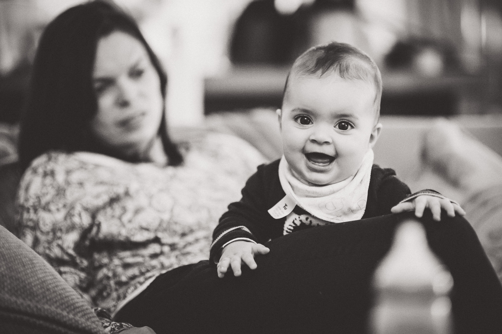 Black and white photo of a woman holding a baby taken by a wedding photographer.
