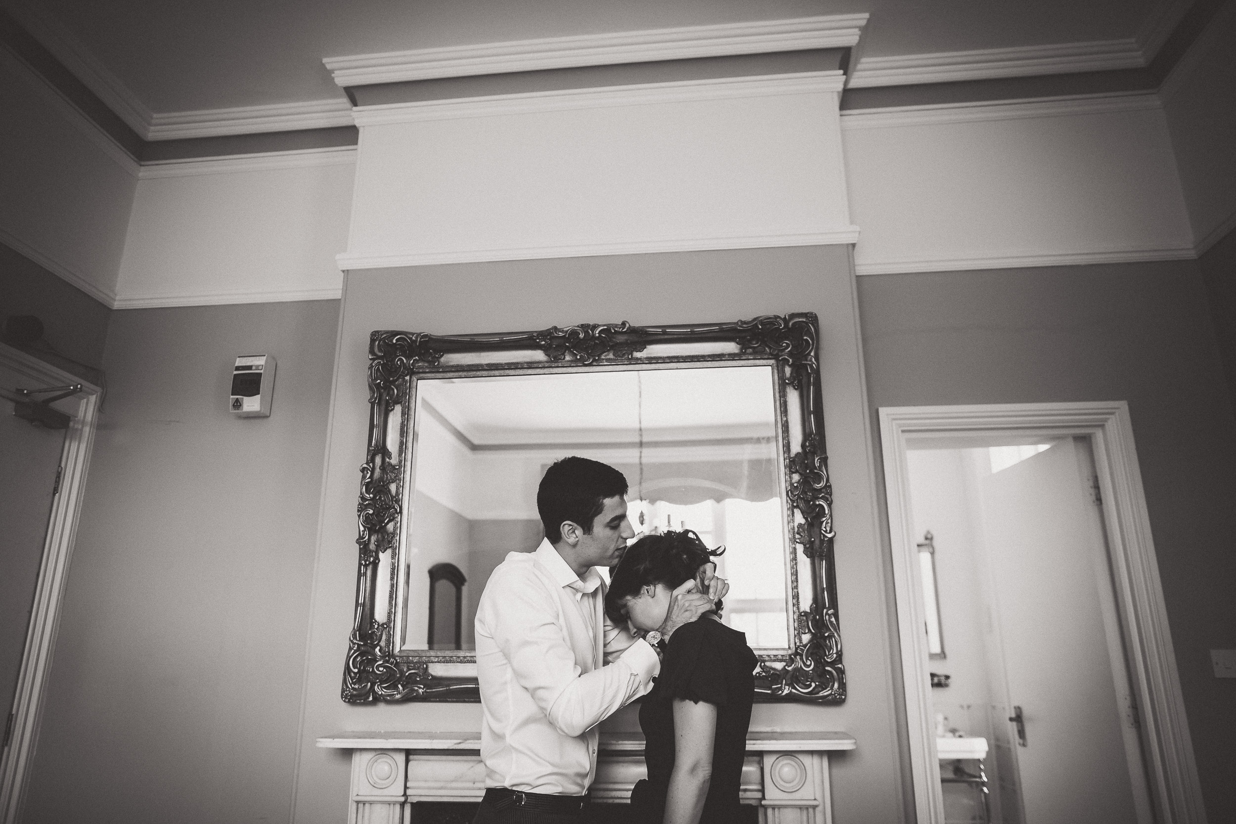 A groom and bride sharing an intimate moment while a wedding photographer captures their kiss.