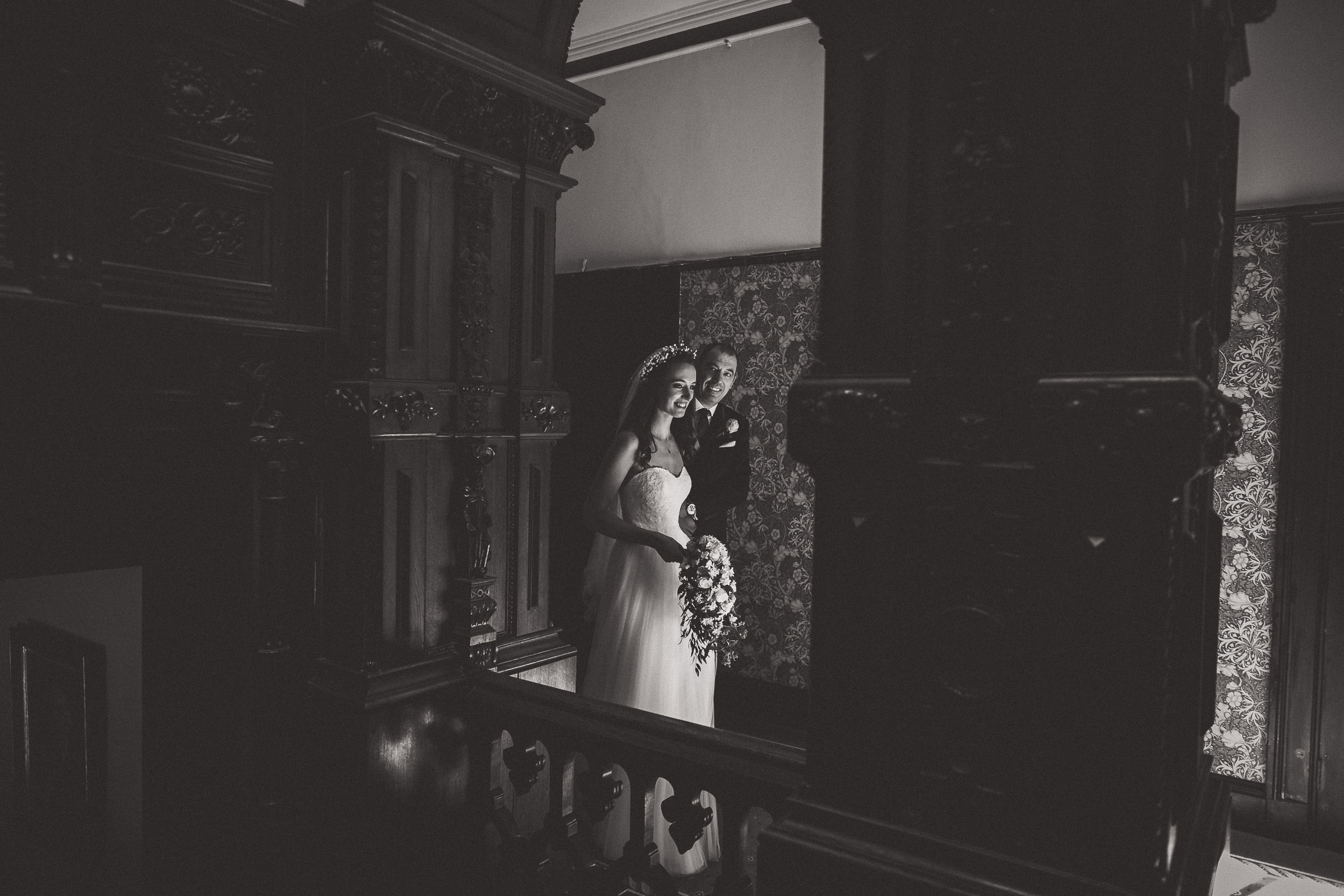 A groom and bride posing at a picturesque staircase for their wedding photographer.