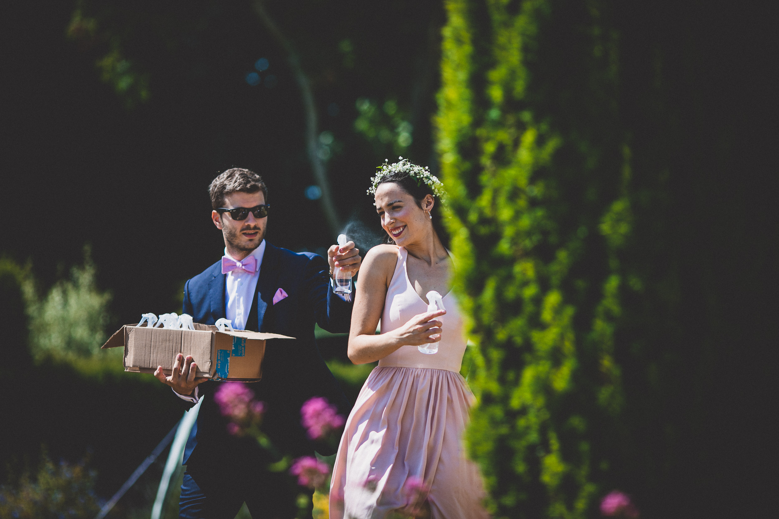 A wedding photographer captures a bride and groom holding a box.