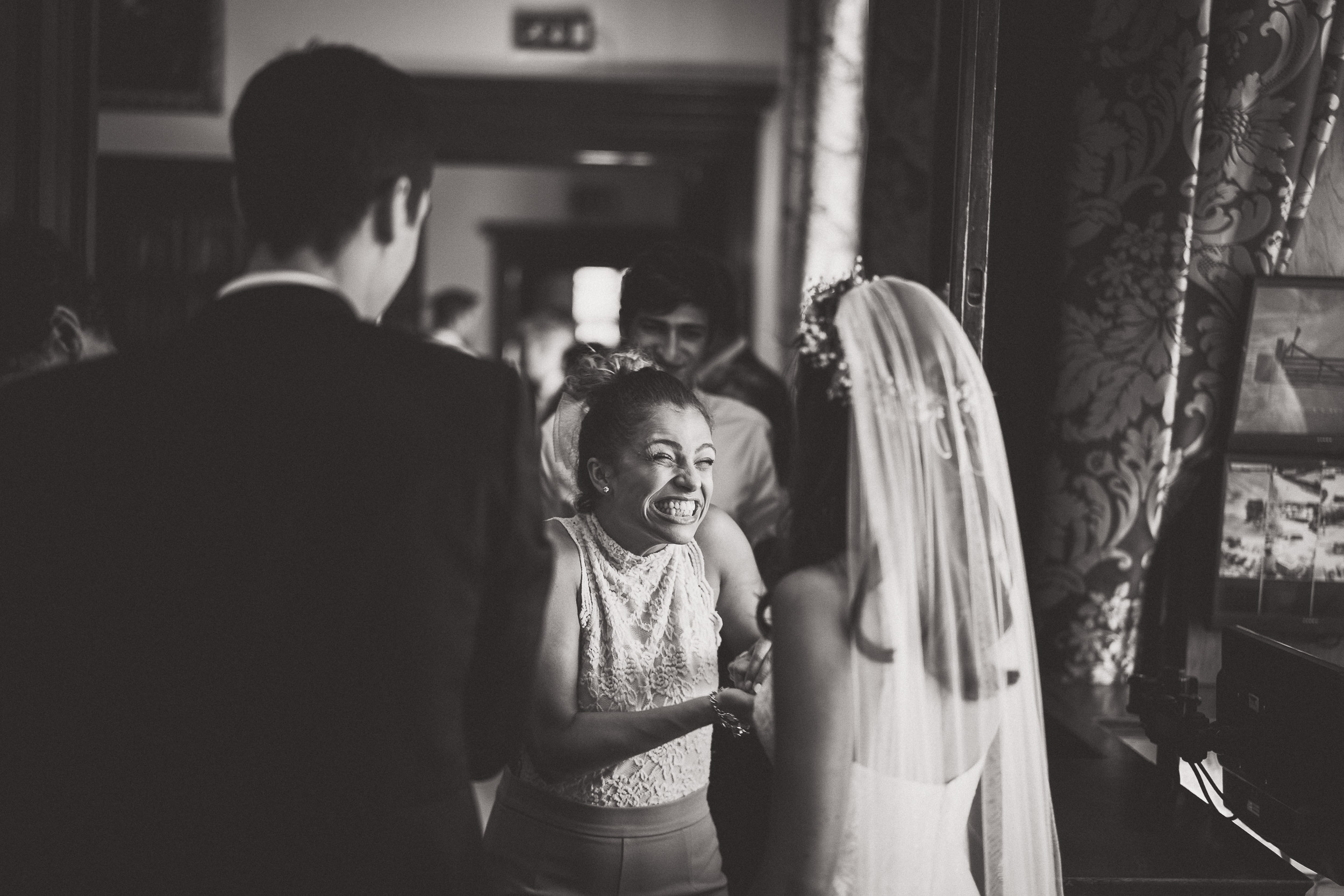 A bride smiles at her bridesmaids in a wedding photo.