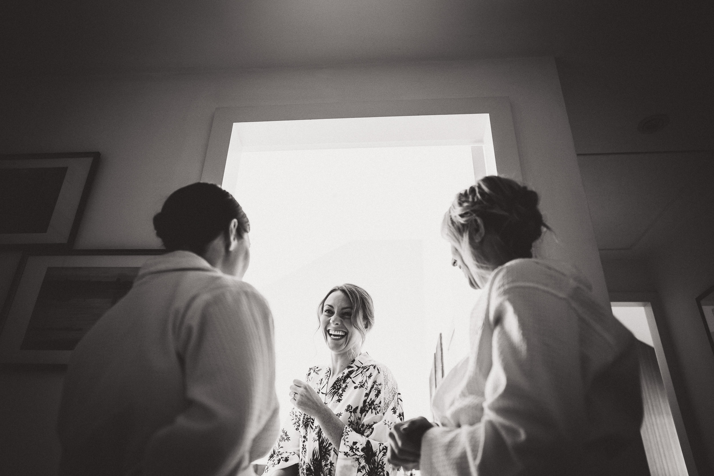 Keywords: wedding, bride

A photographer captures a bride and her bridesmaids admiring the view from a window on her wedding day.