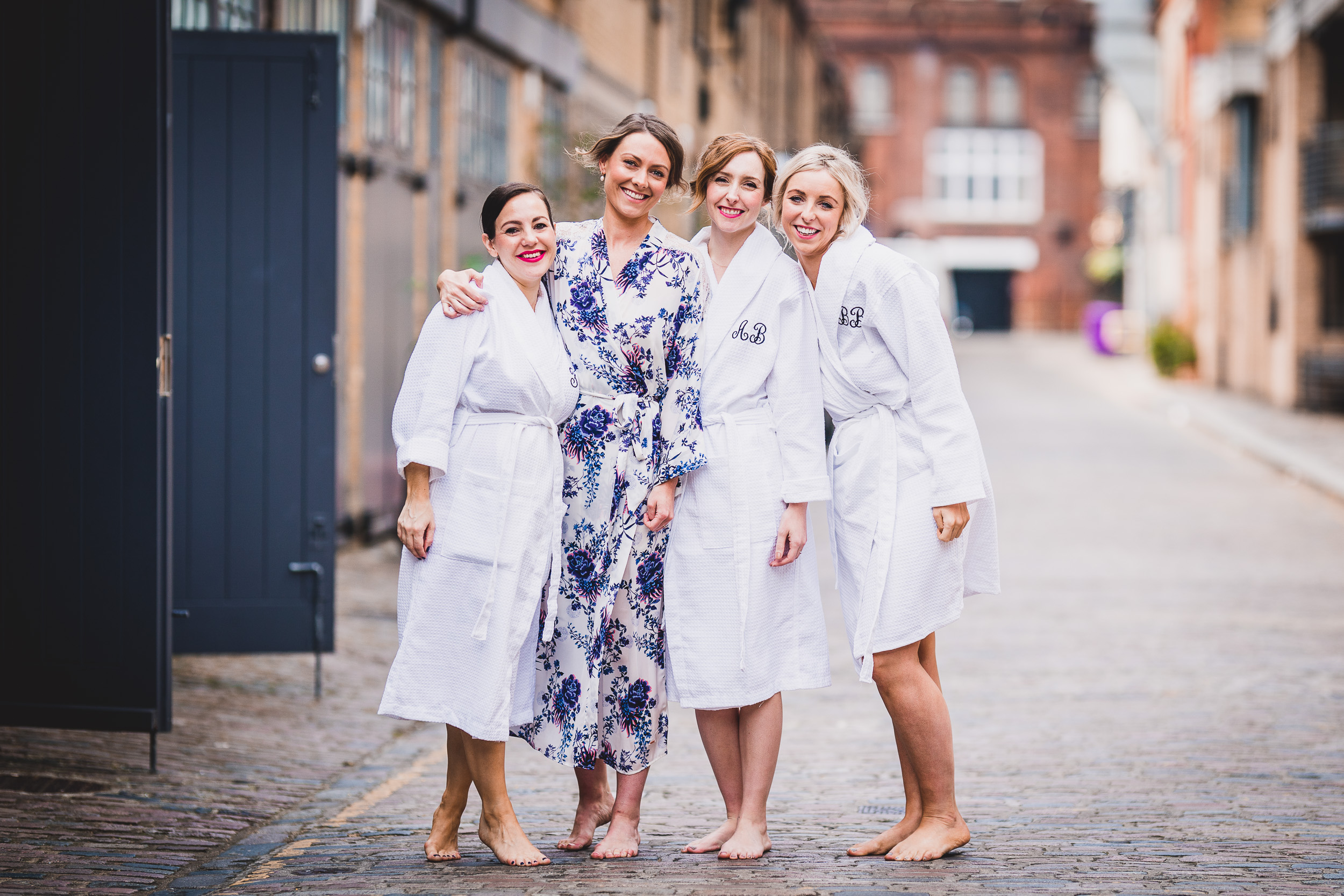 Four bridesmaids in robes posing for a wedding photo.