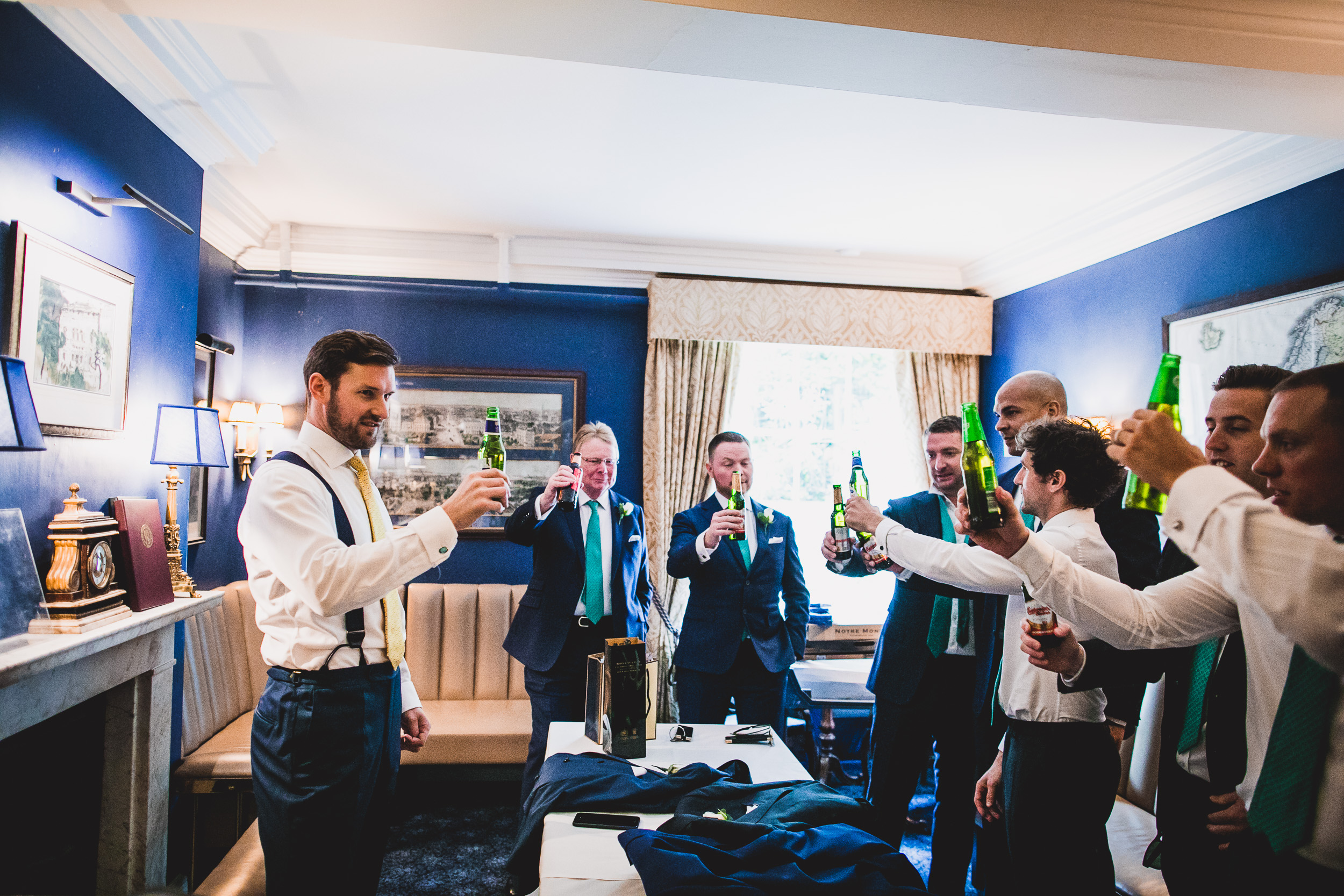 A group of groomsmen toasting during a wedding celebration.