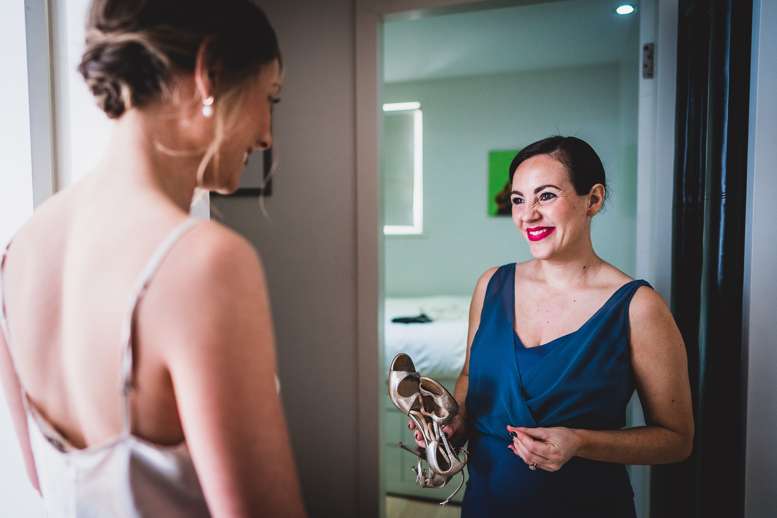 A bride admiring her wedding shoes in a mirror for a wedding photo.