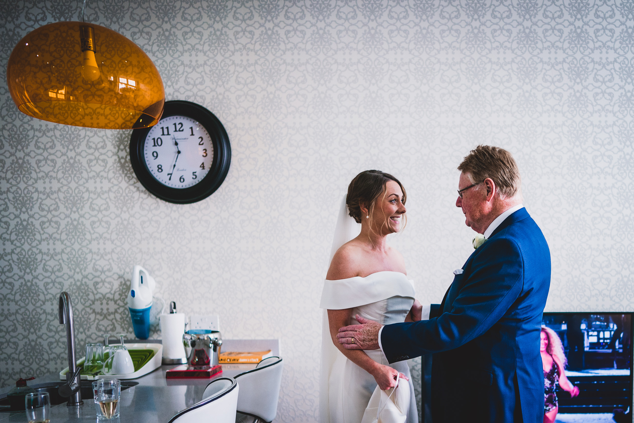 Wedding photographer captures bride and groom posed before a clock backdrop.