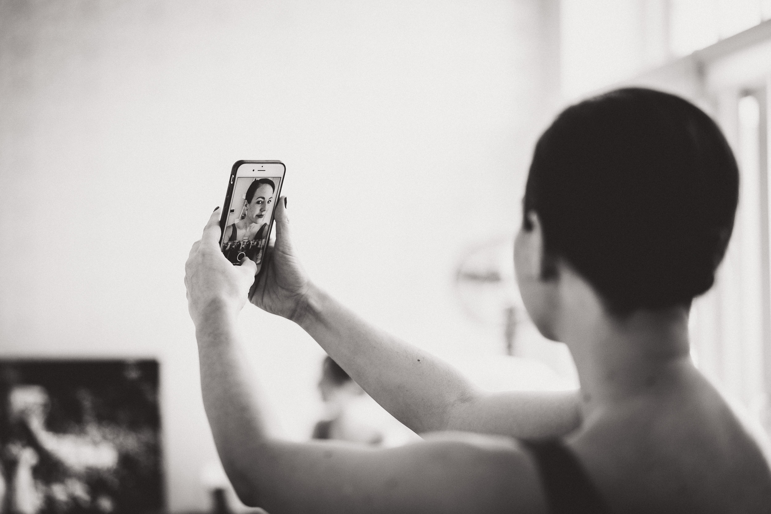 A wedding photographer capturing a moment with her cell phone.