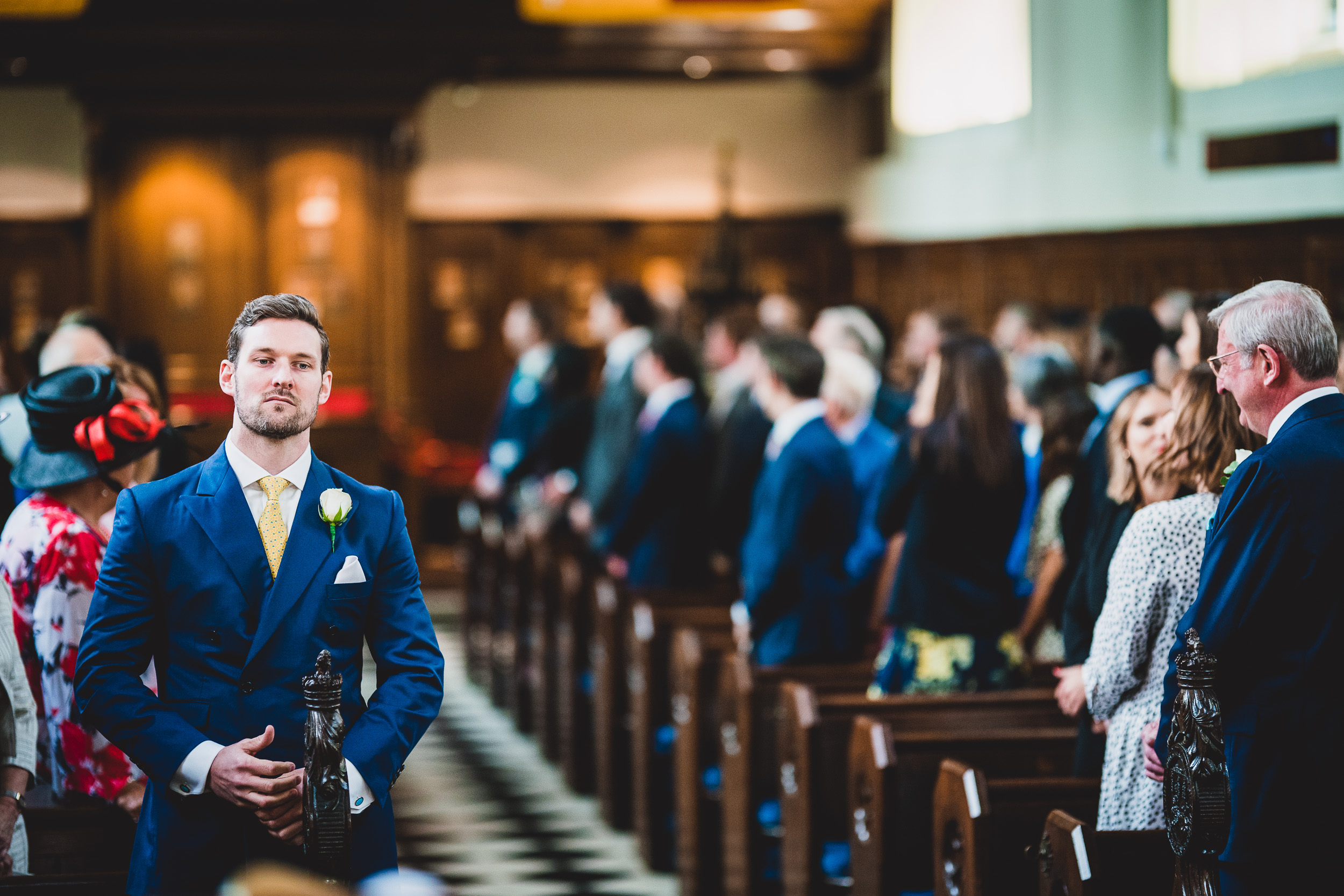 The groom, adorned in a suit, strolls along the wedding aisle.