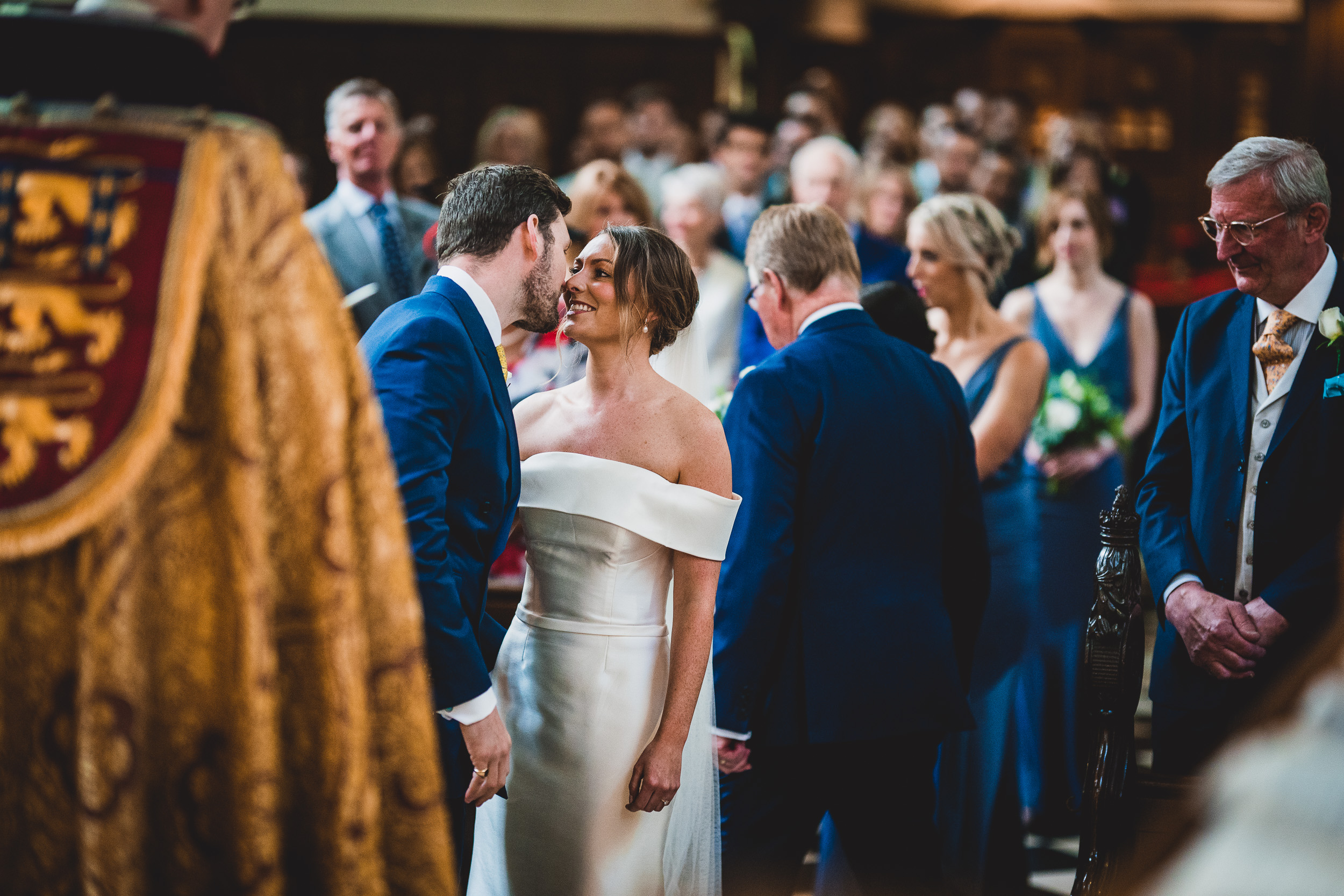 A groom and bride share a kiss captured by their wedding photographer.