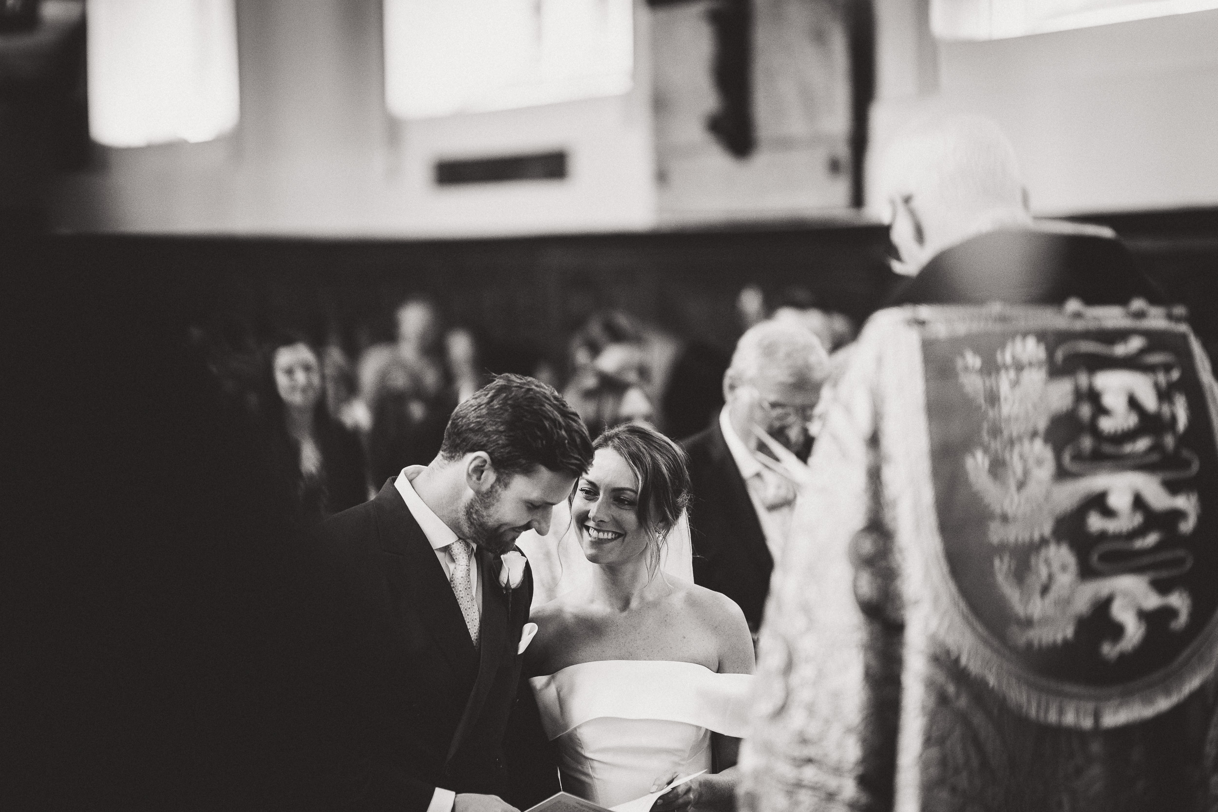 A groom and bride exchange glances captured by a wedding photographer during their ceremony.