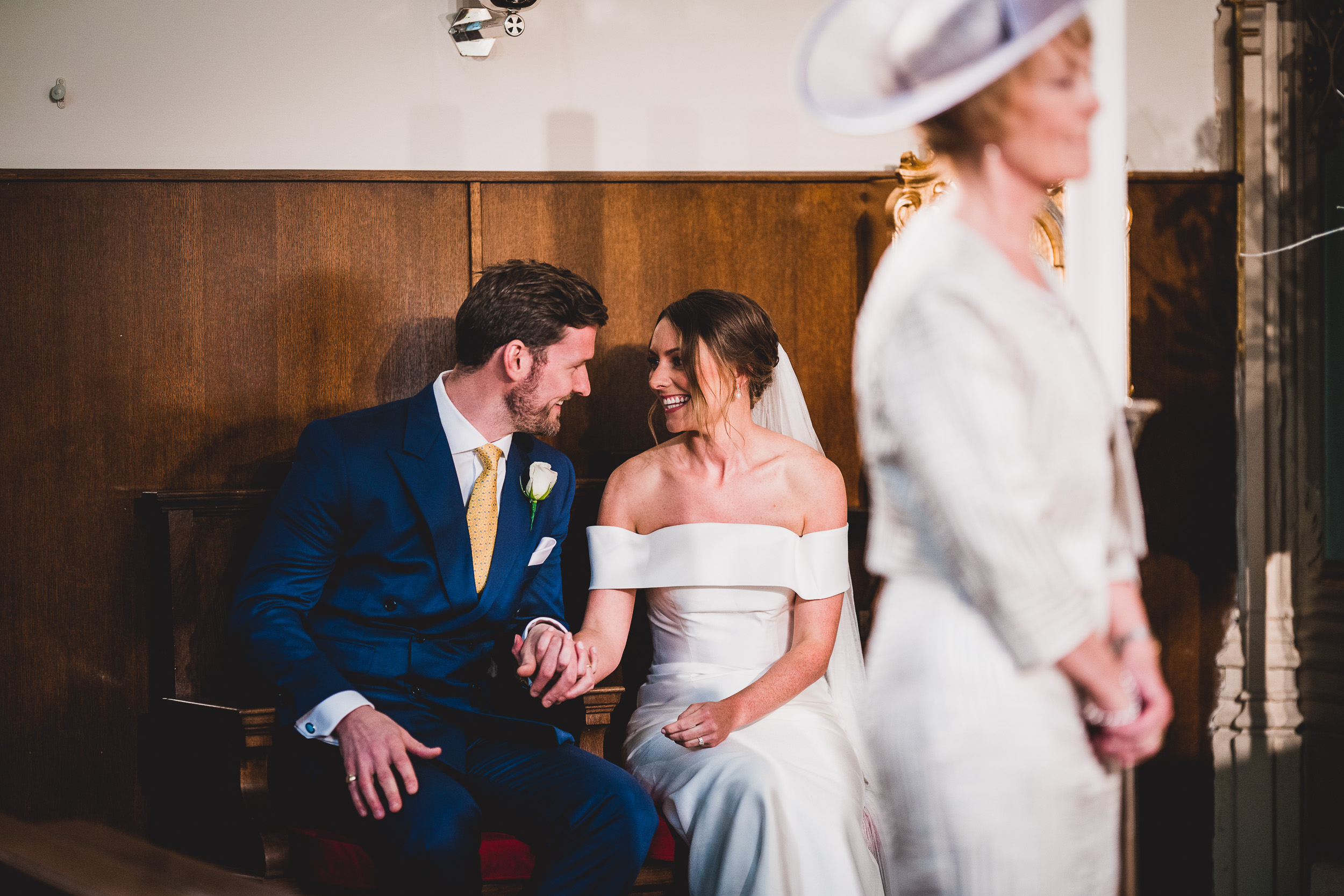 A wedding photographer capturing a precious wedding moment between a bride and groom in a church.