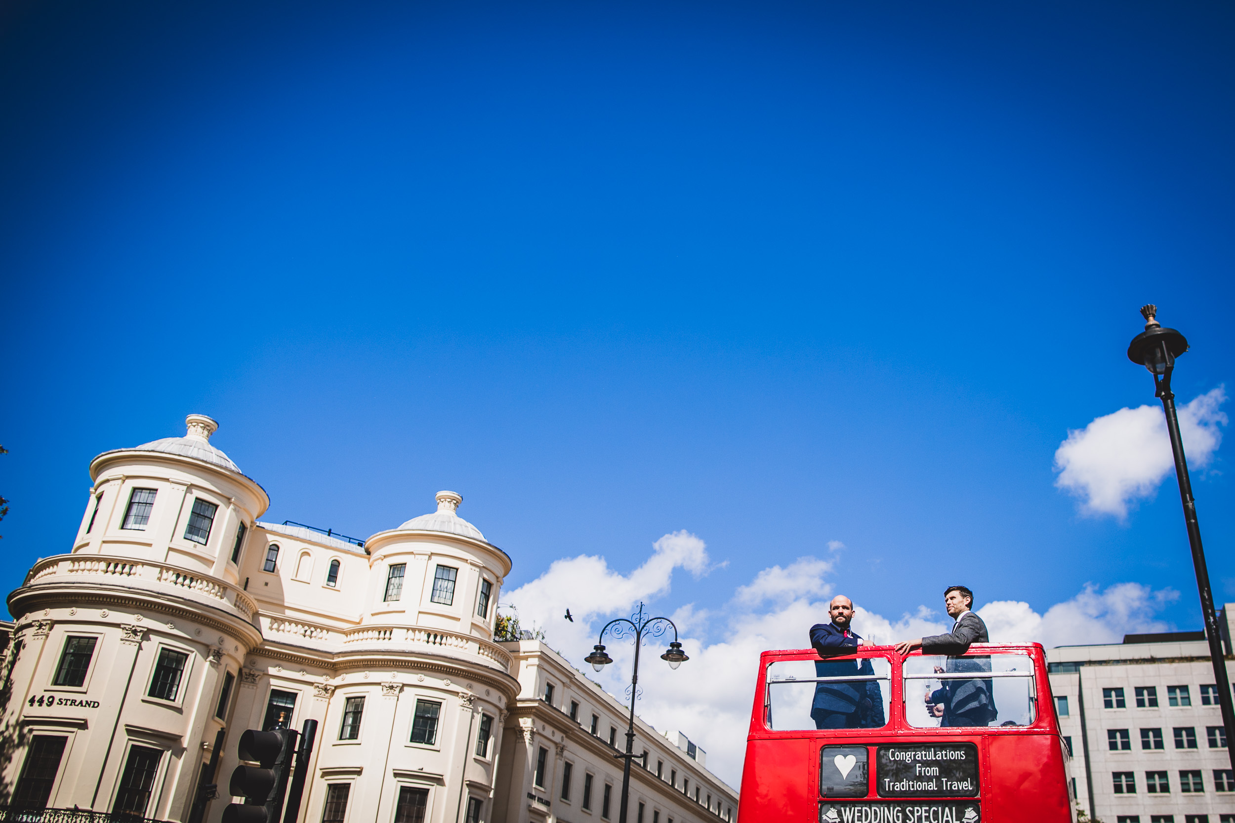 A newlywed couple on a double-decker bus in London.