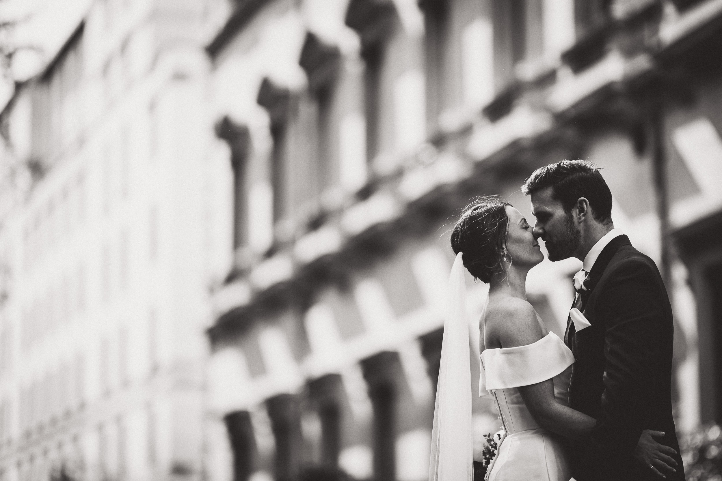 A wedding photo of a bride and groom kissing.