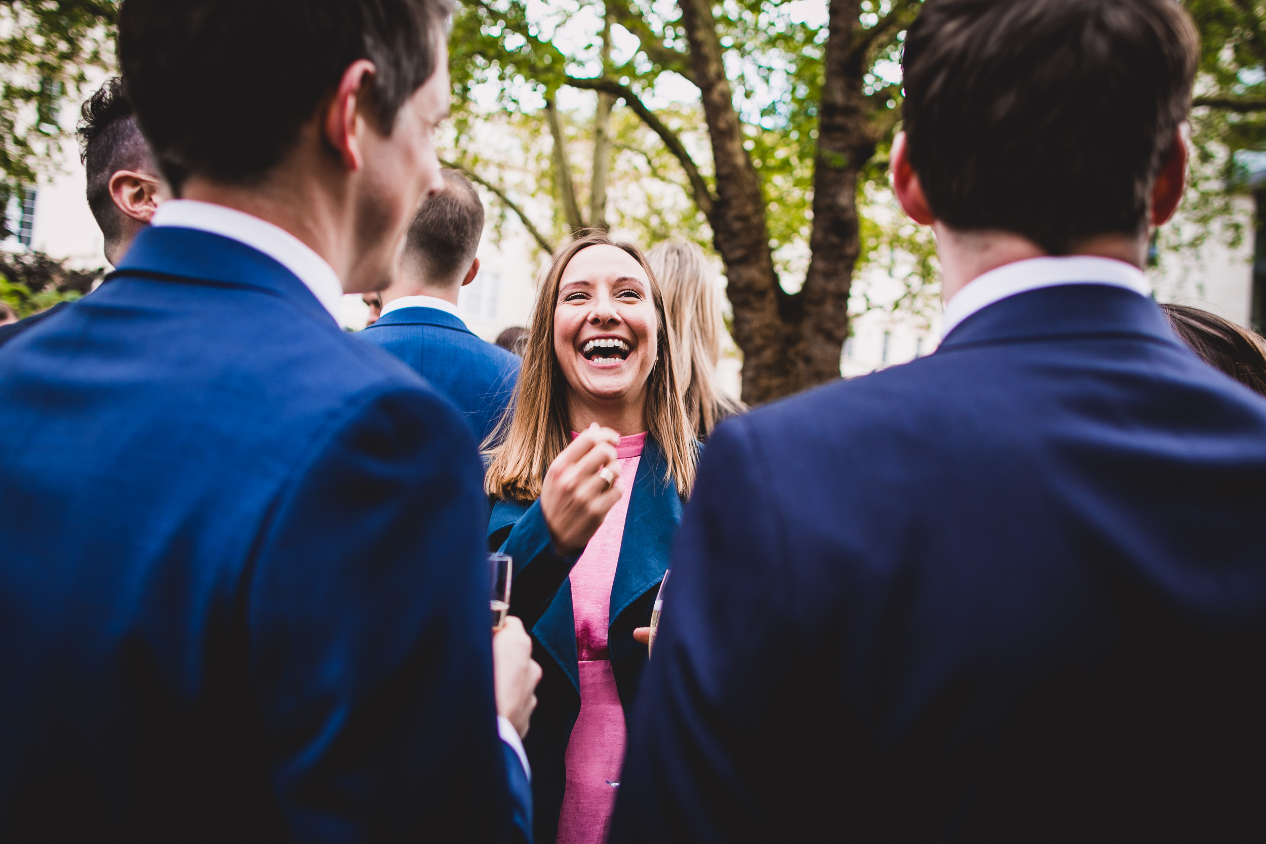 A group of people joyfully celebrating at a wedding party, captured by a wedding photographer.