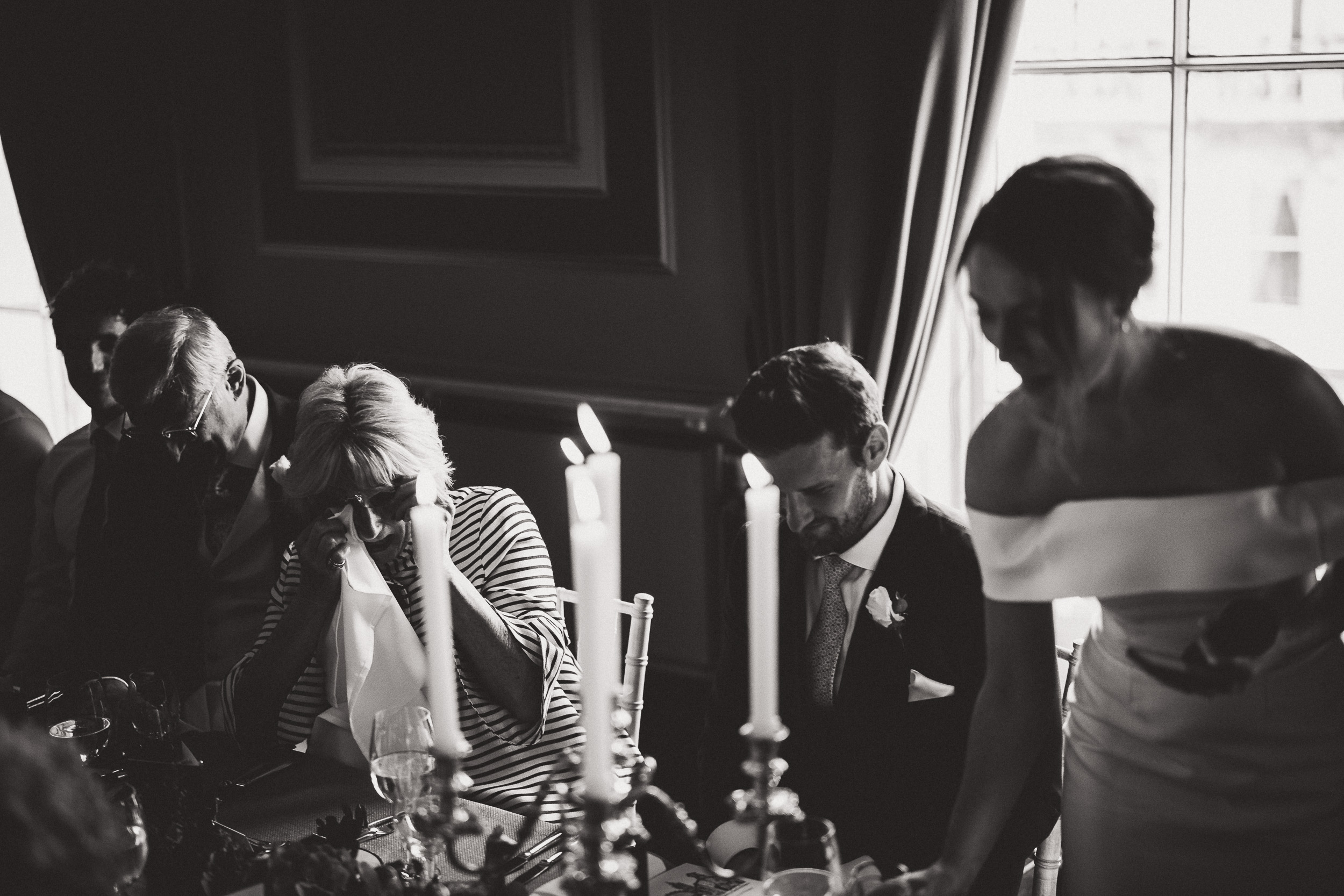 A black and white photo of a group of people at a wedding table.