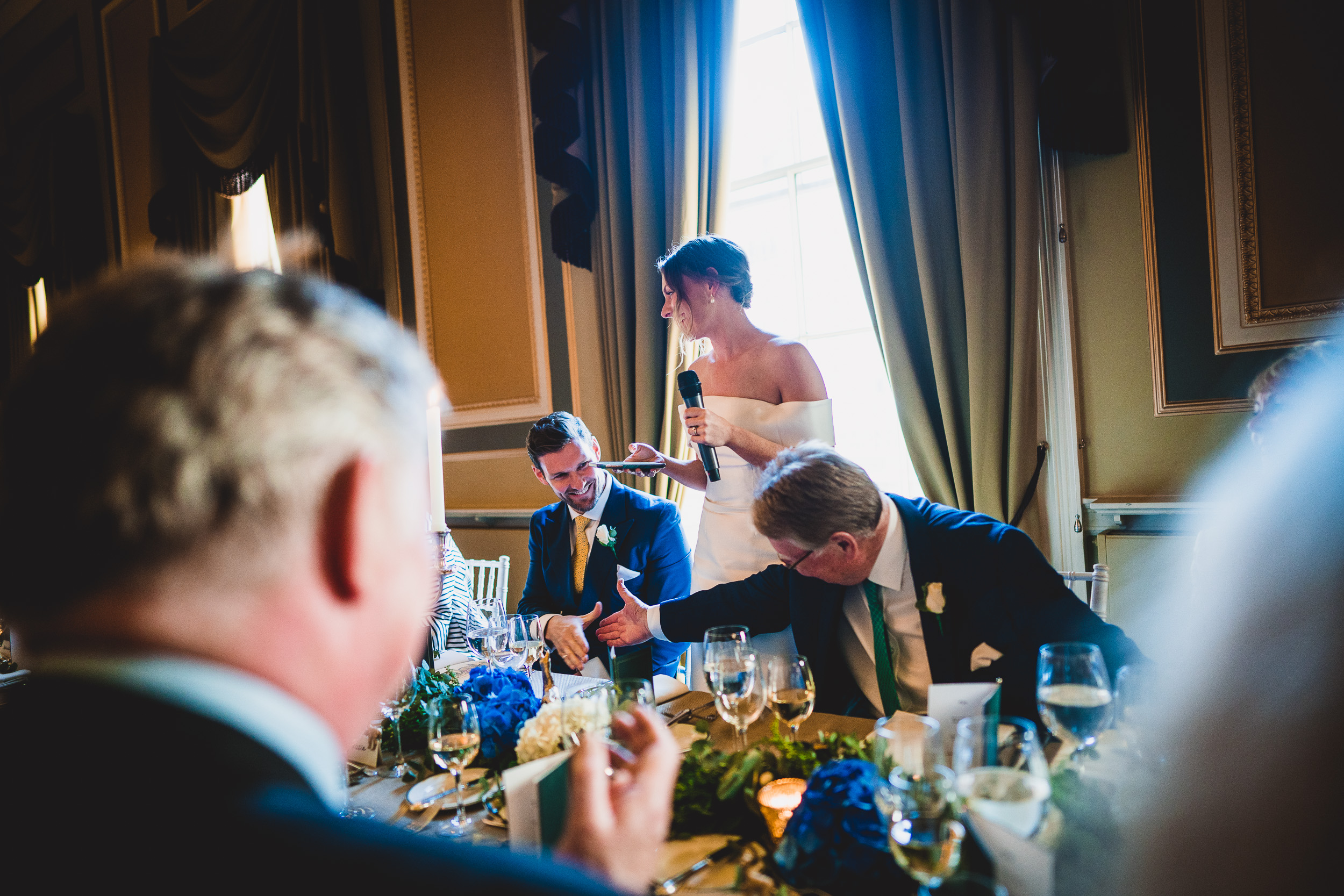 A wedding photo capturing the bride and groom at a table.