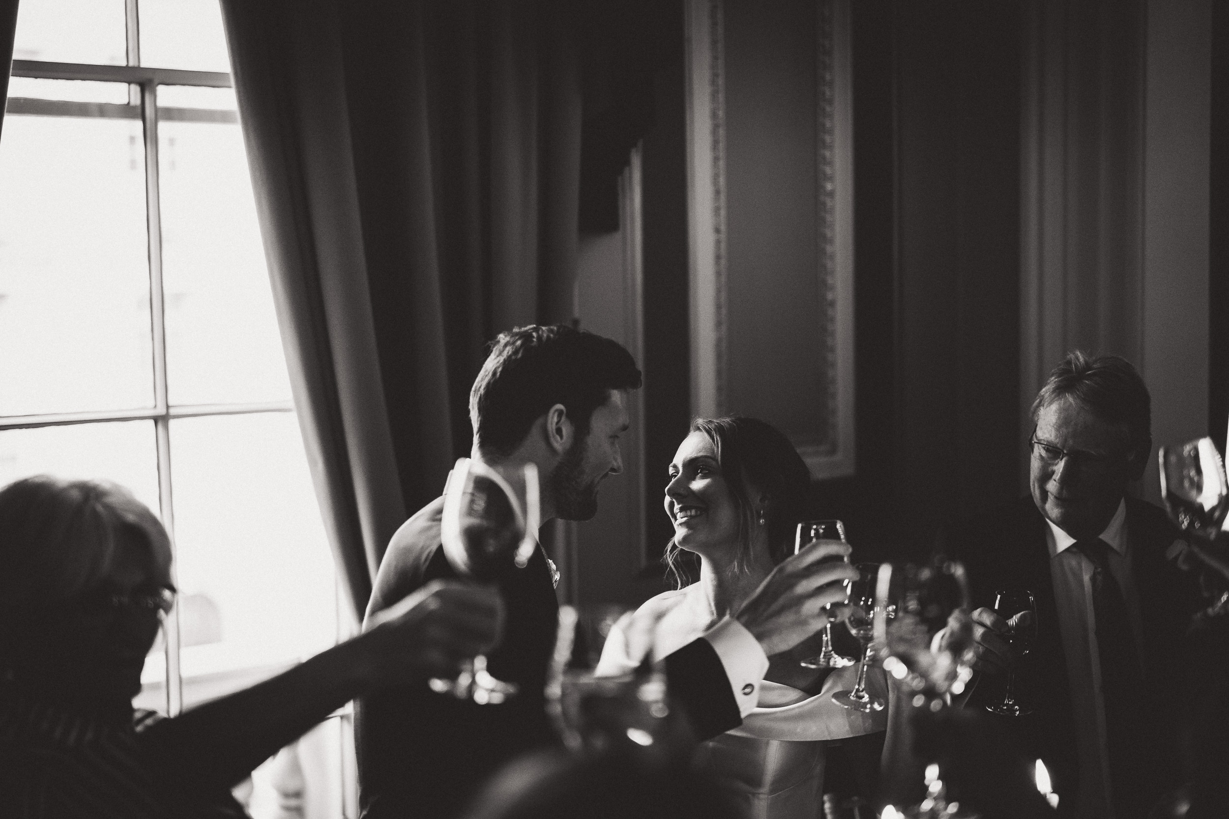 A groom toasting at a wedding reception captured by a wedding photographer.