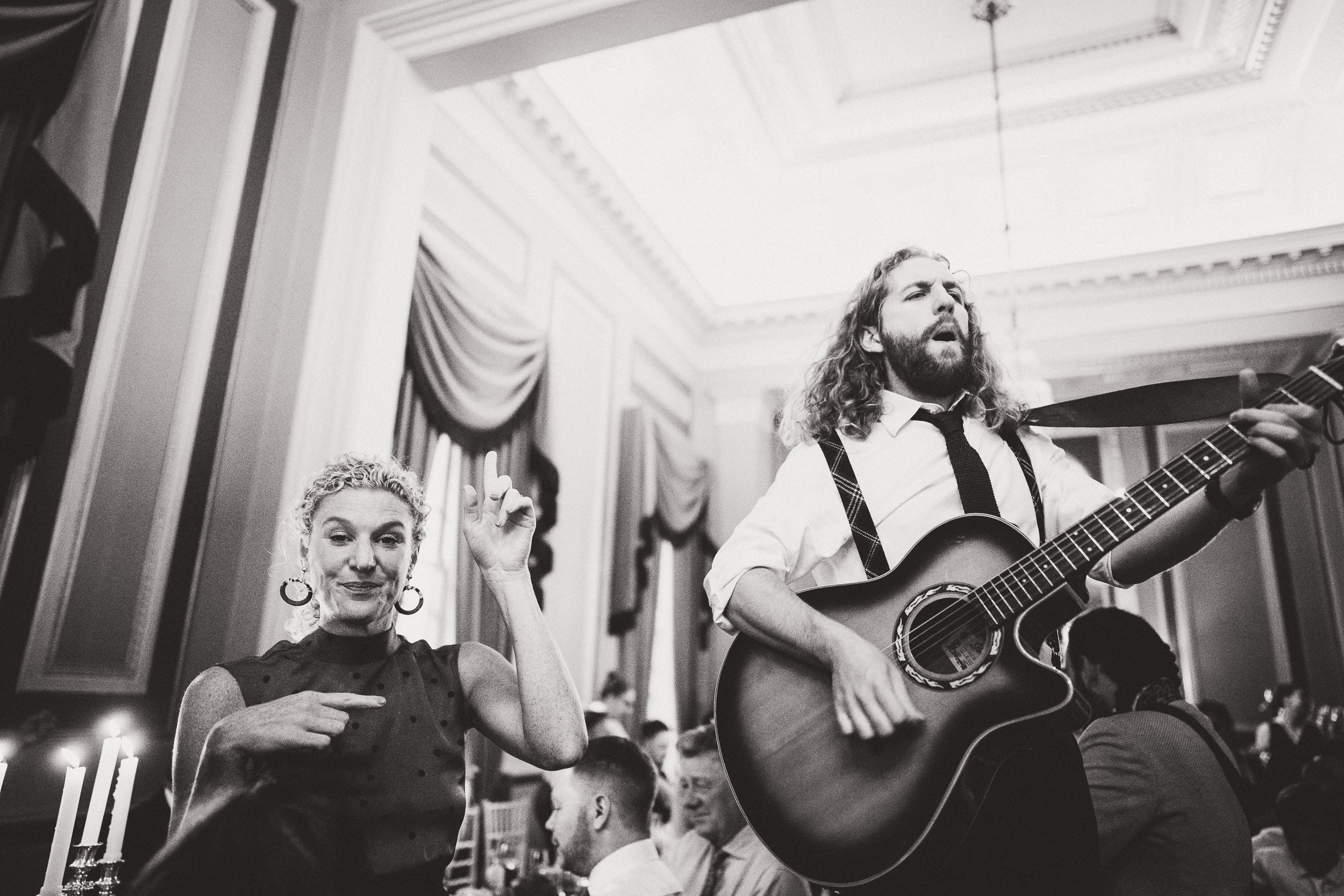 A couple serenading each other with an acoustic guitar during their wedding ceremony photographed by a wedding photographer.