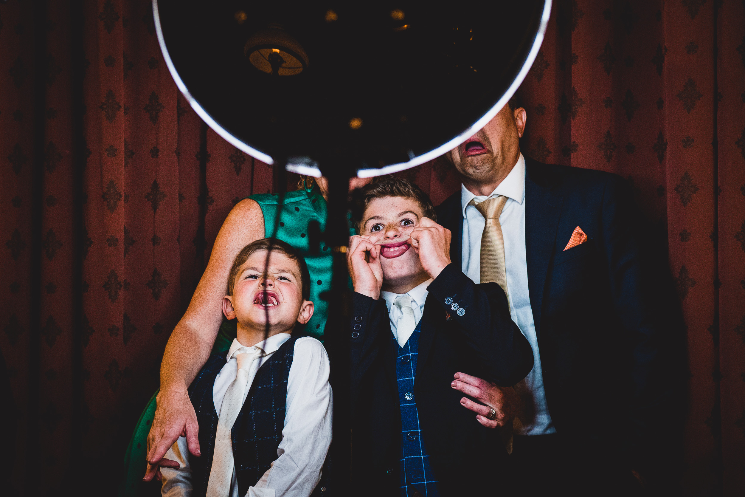 A wedding family photo captured by a wedding photographer in front of a mirror.