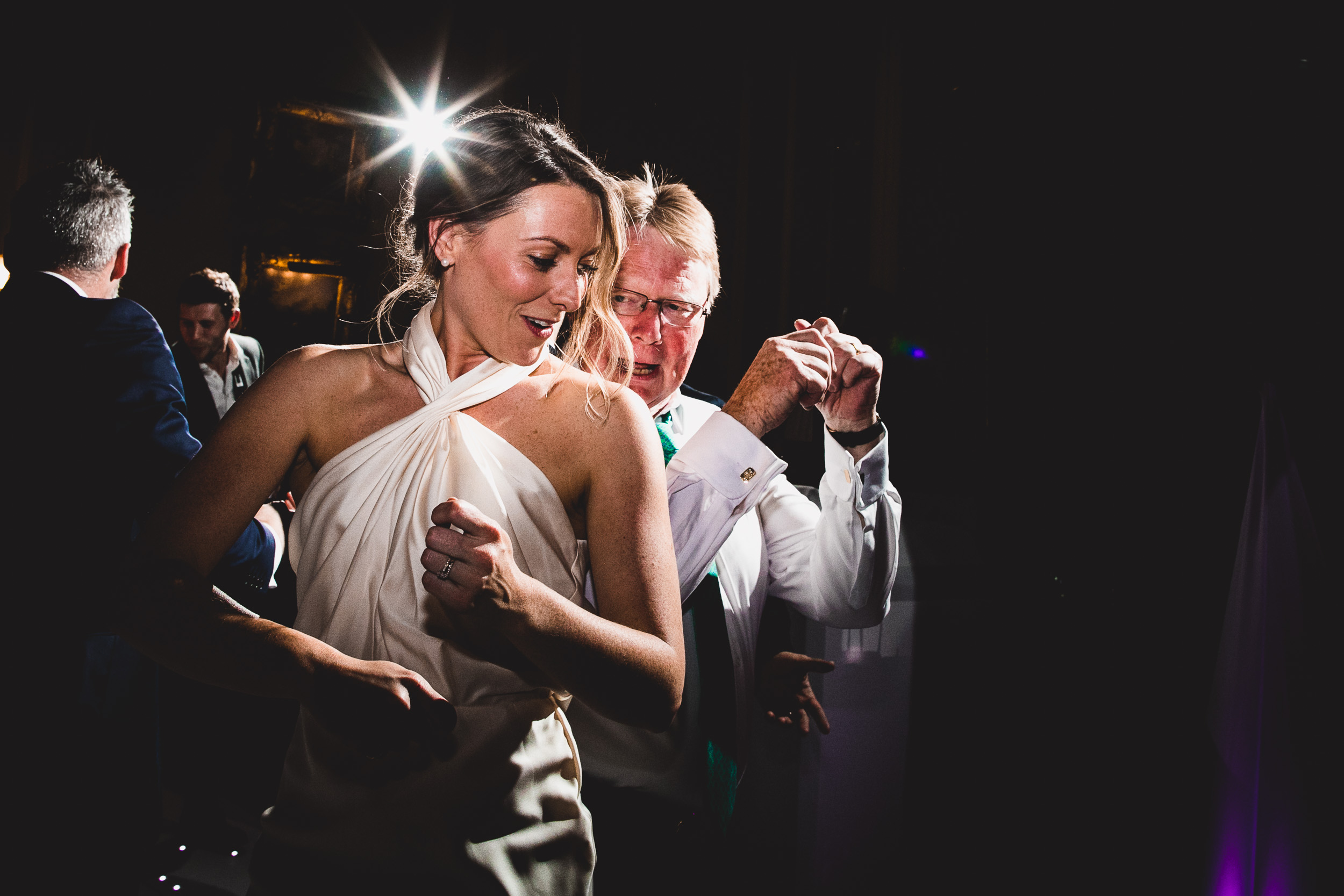 A groom and his bride dancing at their wedding reception, captured by a wedding photographer.