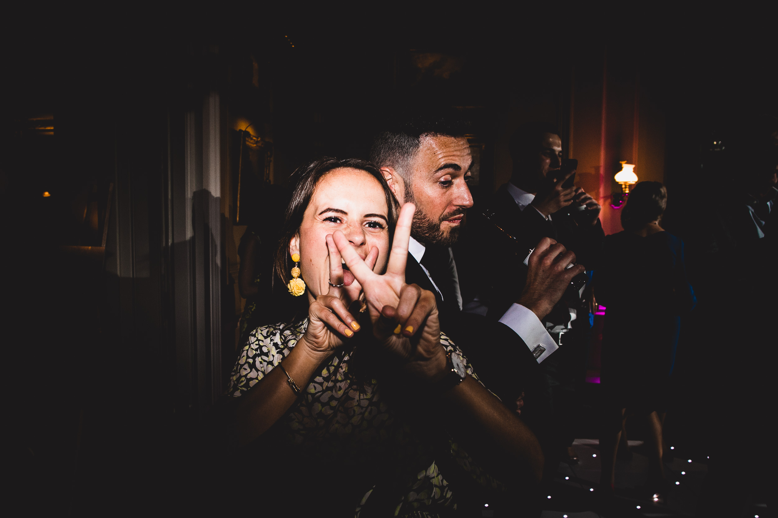 A bride and groom making a peace sign in their wedding photo.