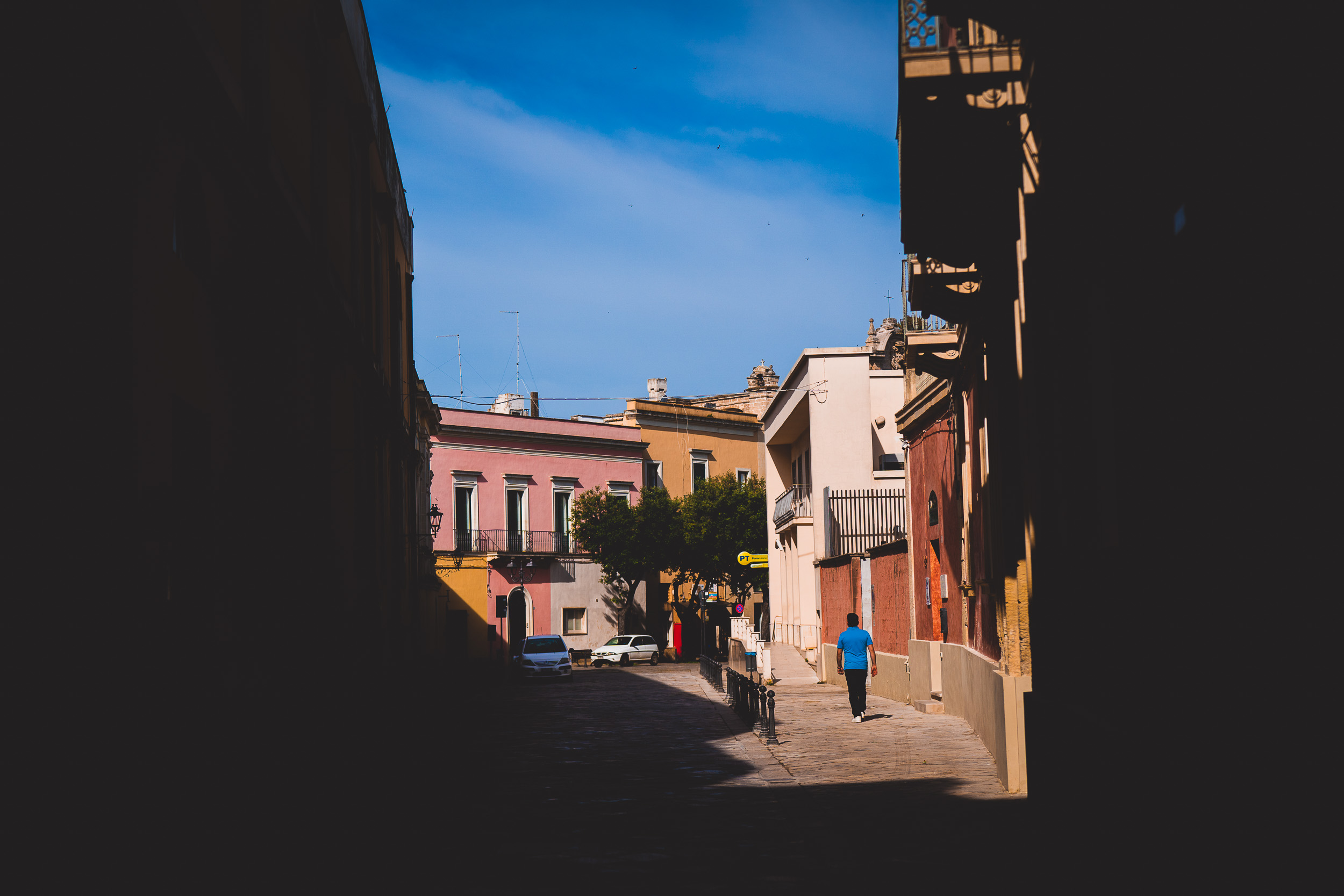 A groom is walking down a narrow street.