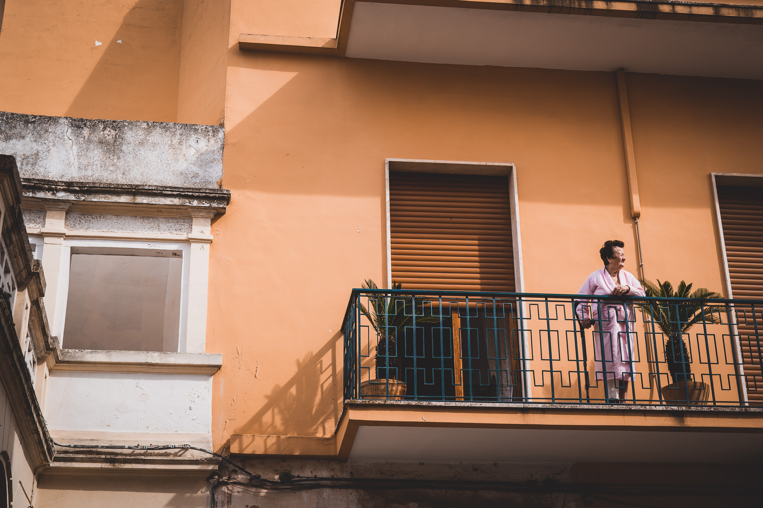 A bride standing on the balcony of an apartment building.