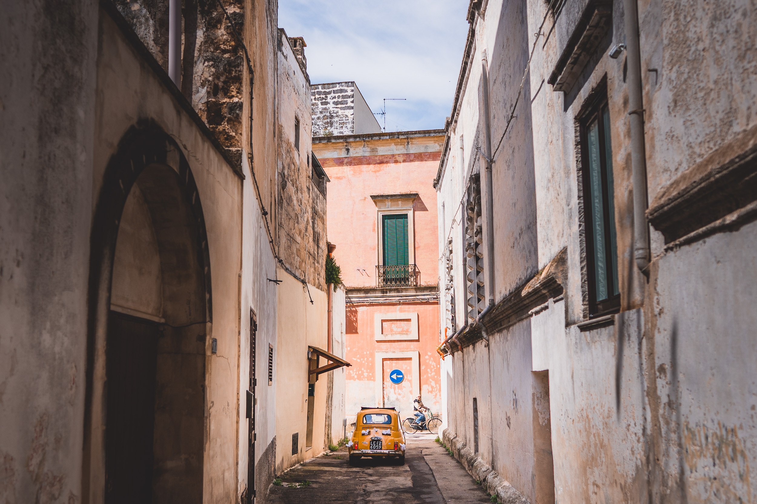 A narrow alleyway with a yellow car perfect for a wedding photographer capturing the bride and groom's special moments.