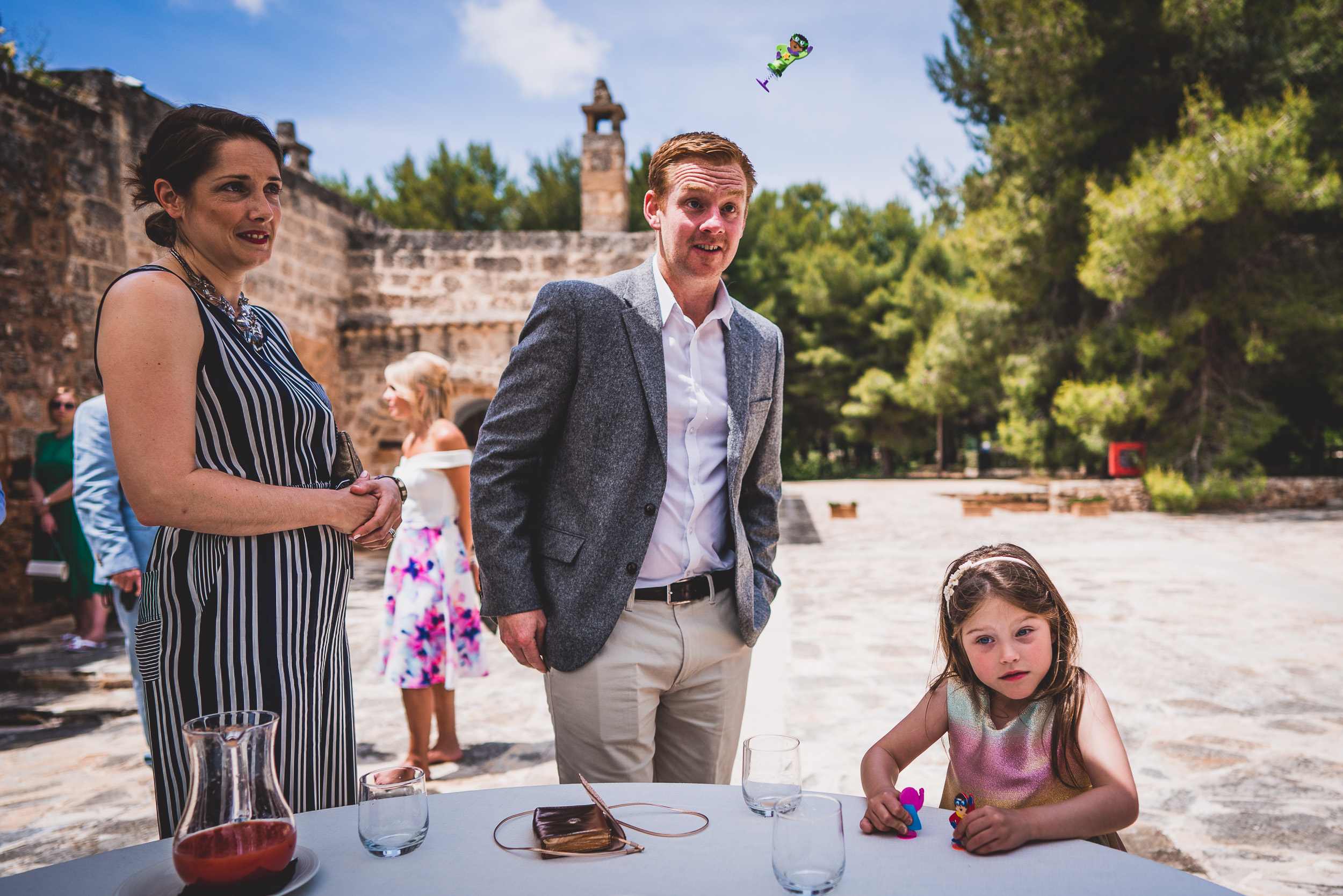 A bride and groom with a little girl posing for a wedding photo.