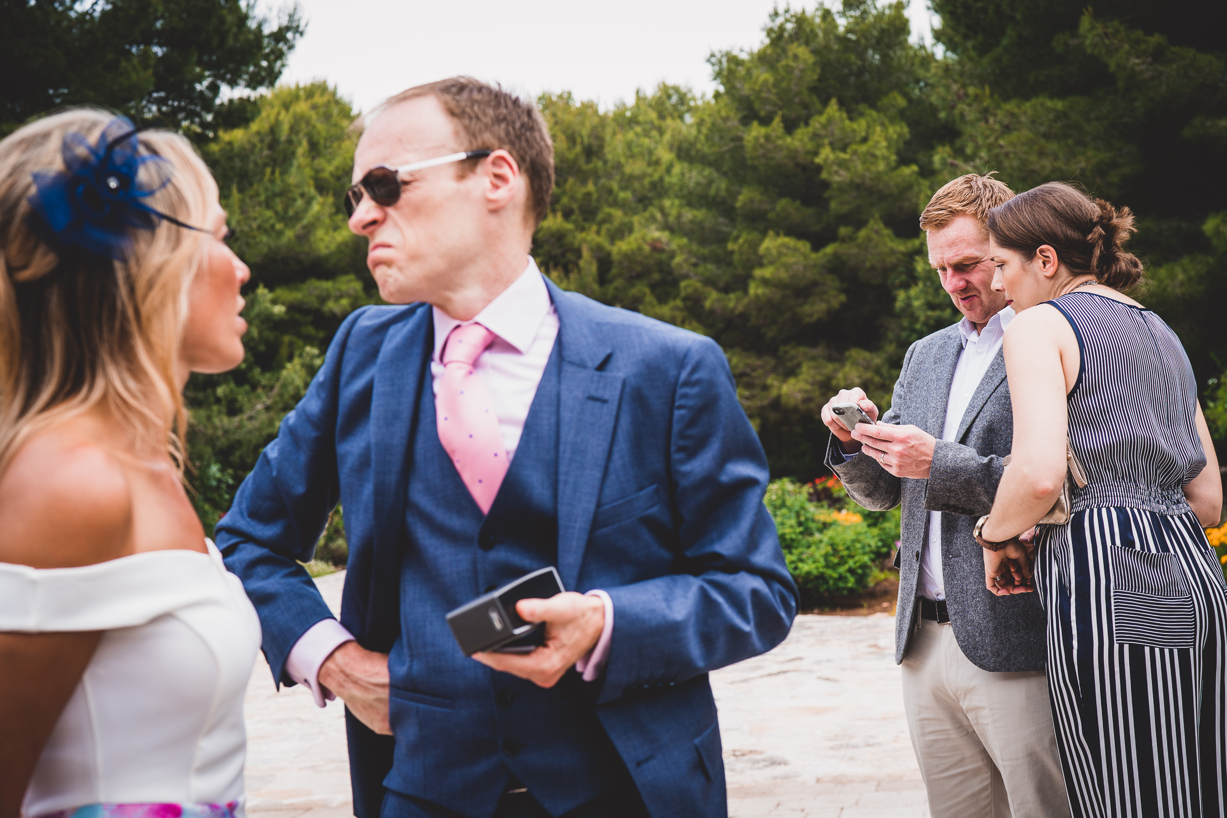 A groom is talking to a wedding photographer.