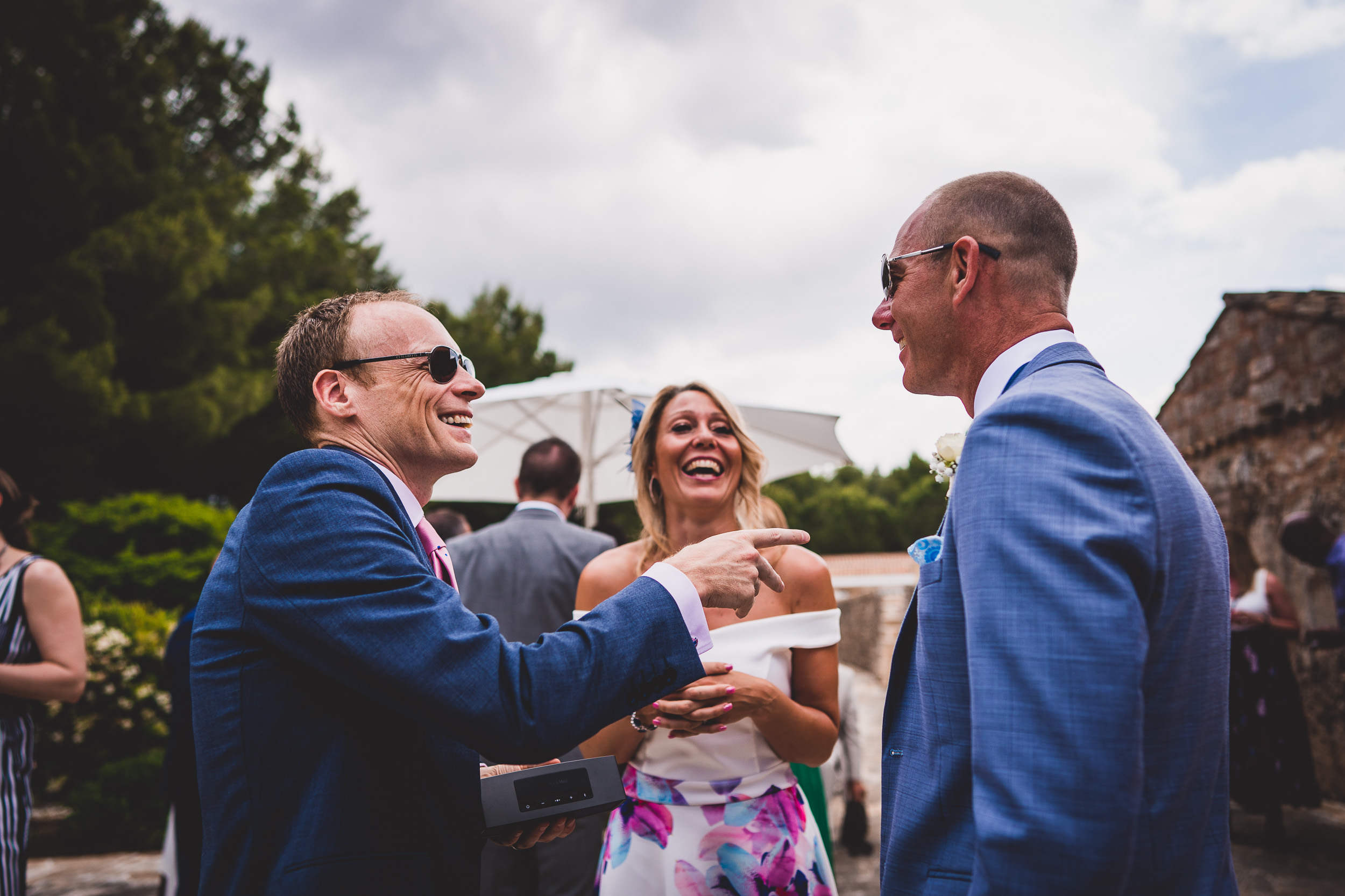 A groom and a wedding photographer conversing at a ceremony.