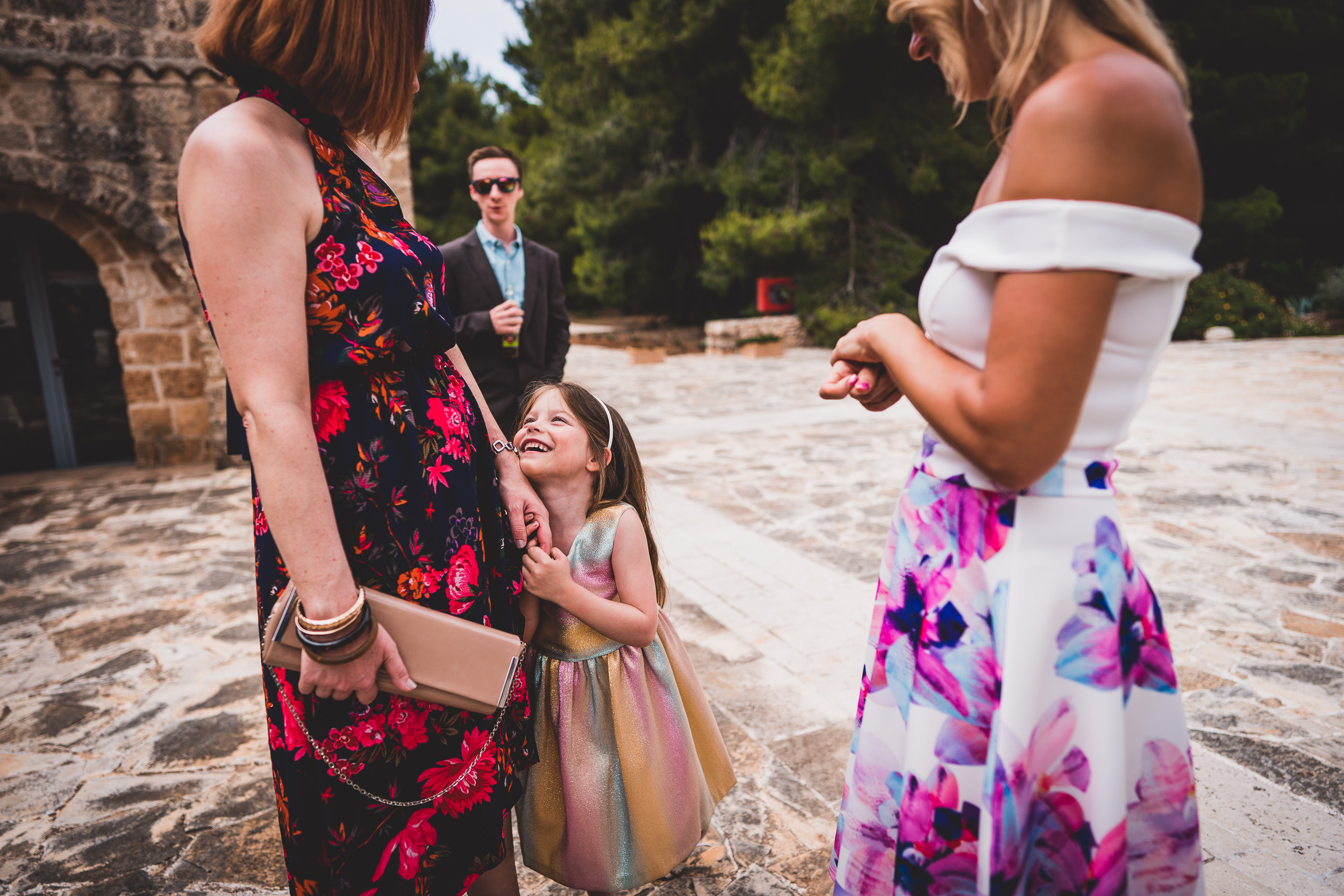 A little girl is chatting with the wedding photographer near the bride.