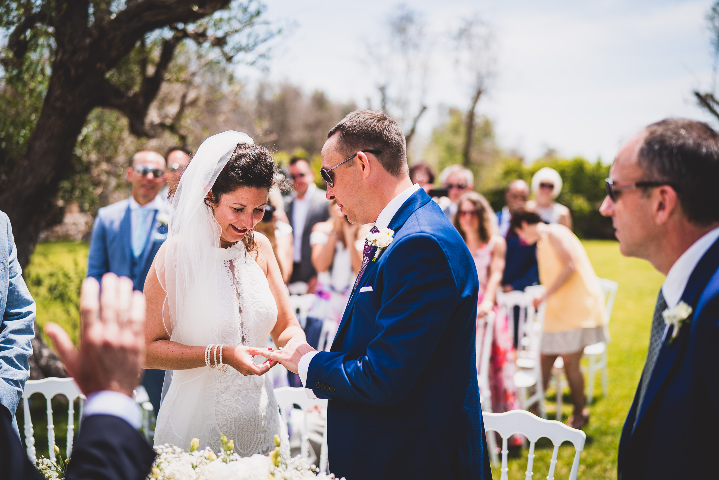 A wedding photographer capturing a bride and groom exchanging their rings during the ceremony for a memorable wedding photo.