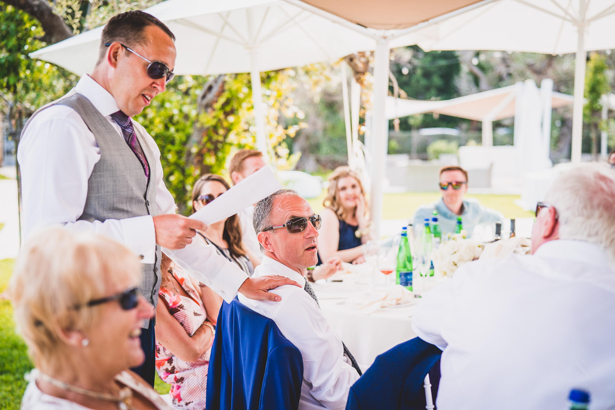 A groom is giving a speech to a group of people at his wedding.