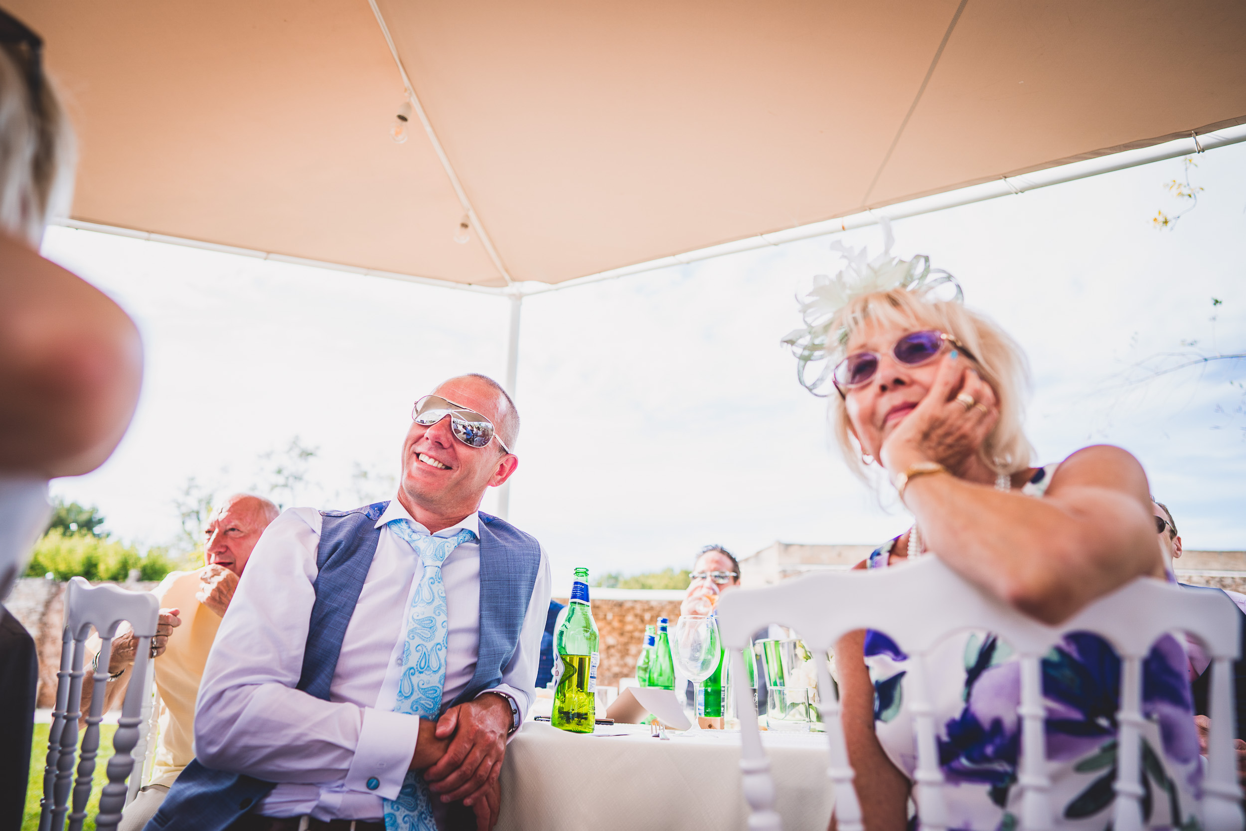 A groom and bride sitting at a table during their wedding reception.