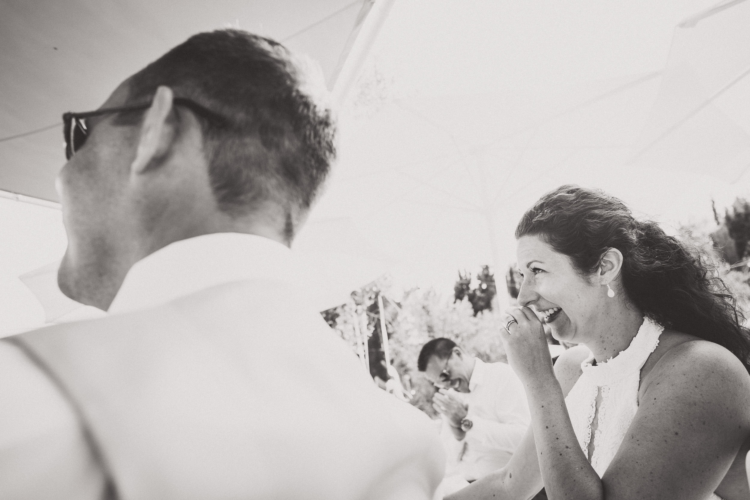 A wedding photographer captures a joyful groom and bride in a black and white photograph.