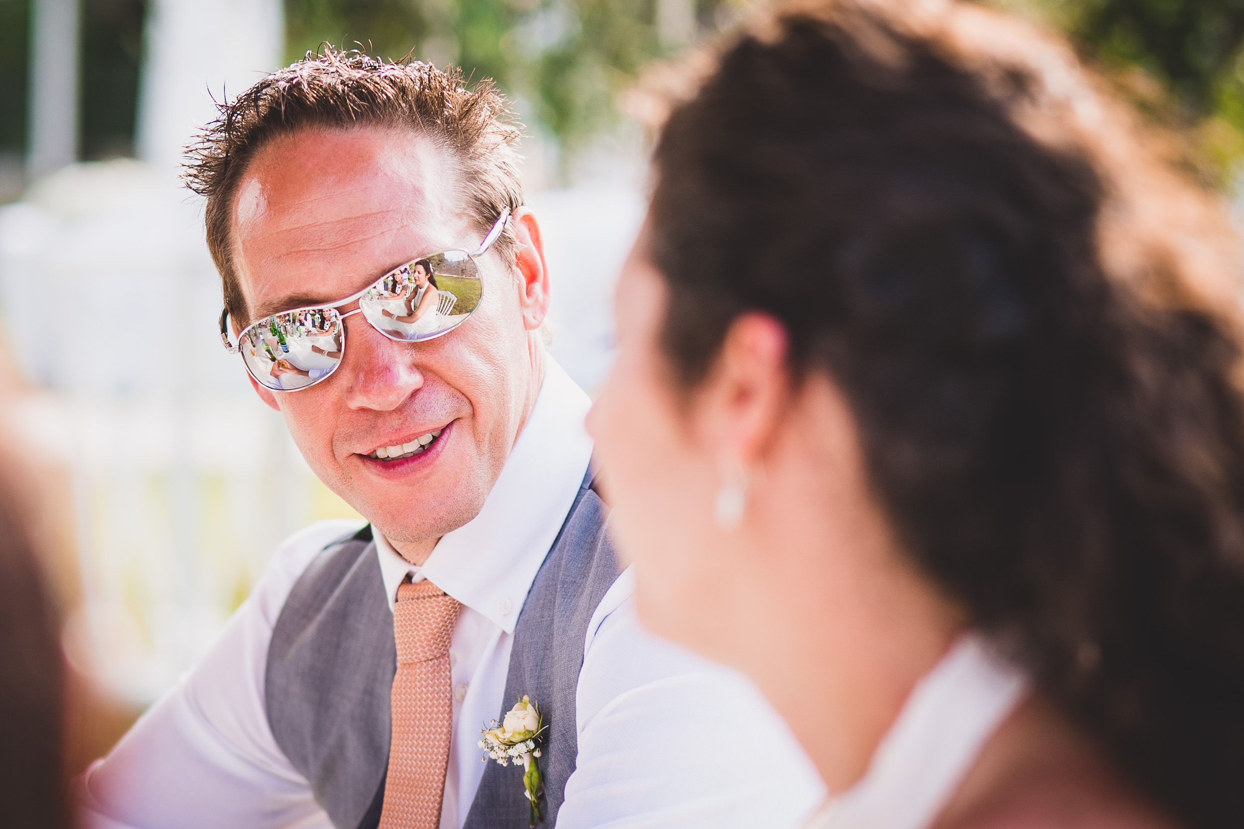 A groom wearing sunglasses at his wedding.