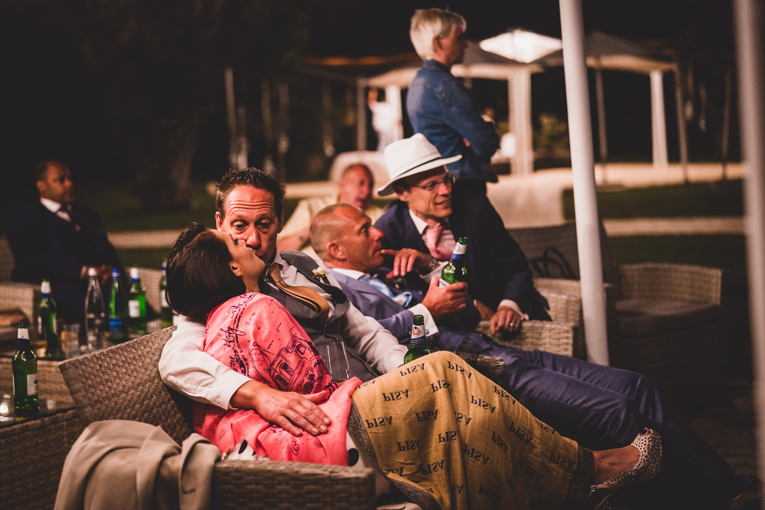 A group of people sitting on chairs at a wedding party.