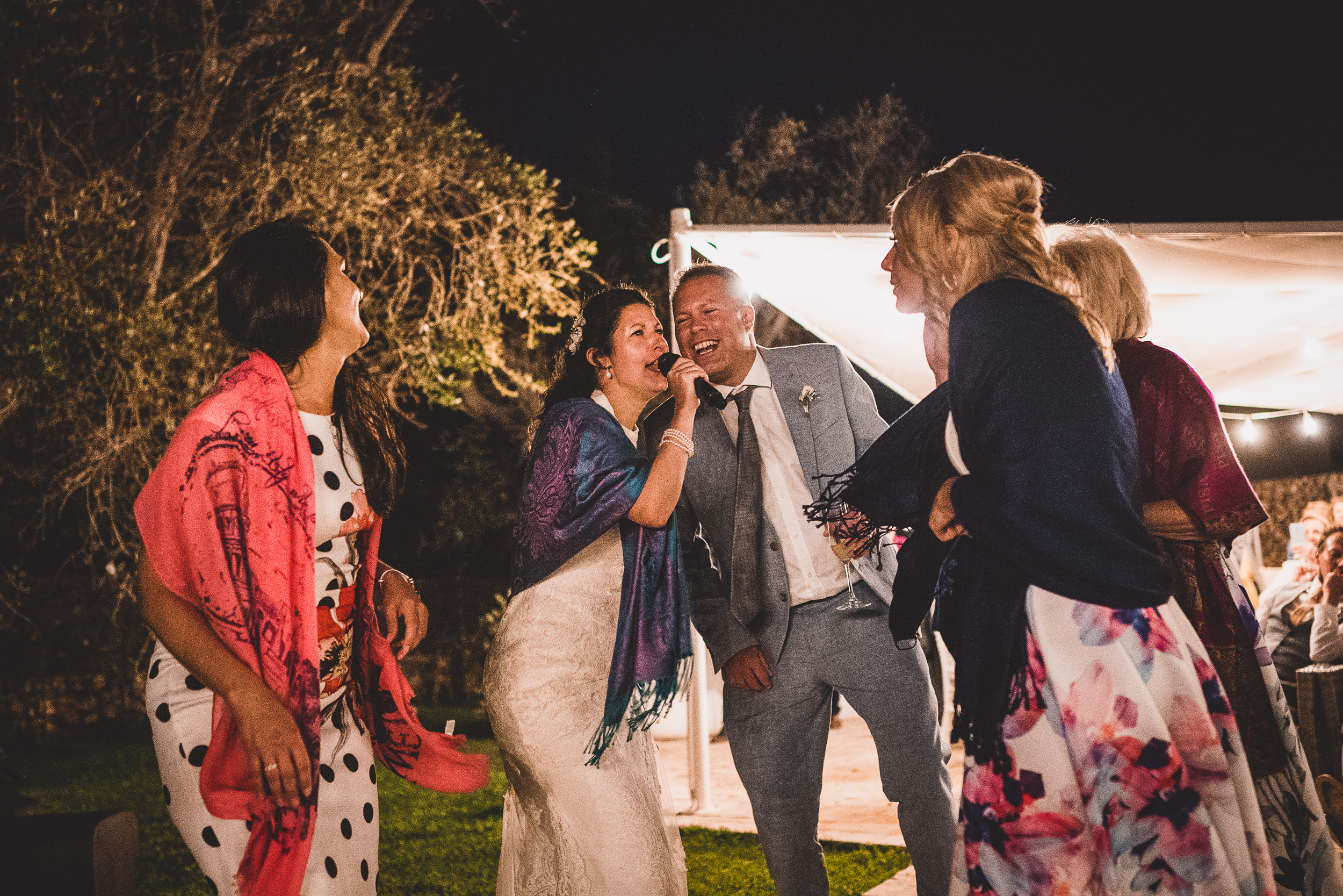 A group of grooms and brides posing for a wedding photo.