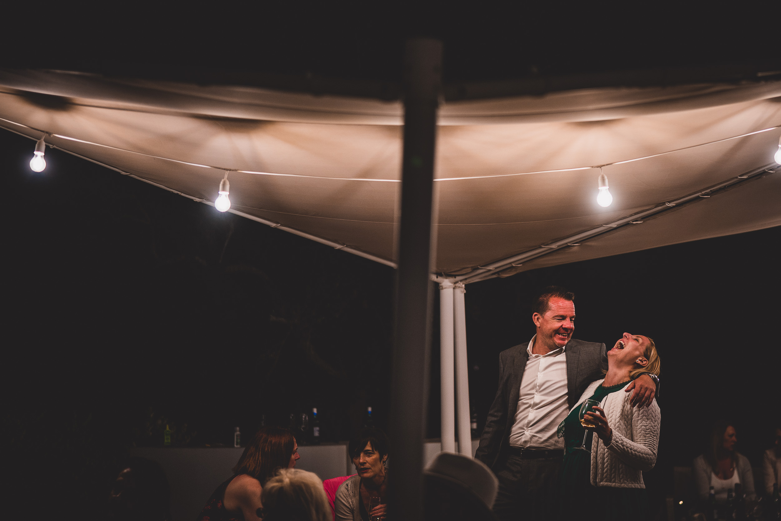 A bride and groom posing under the night sky for their wedding photographer.