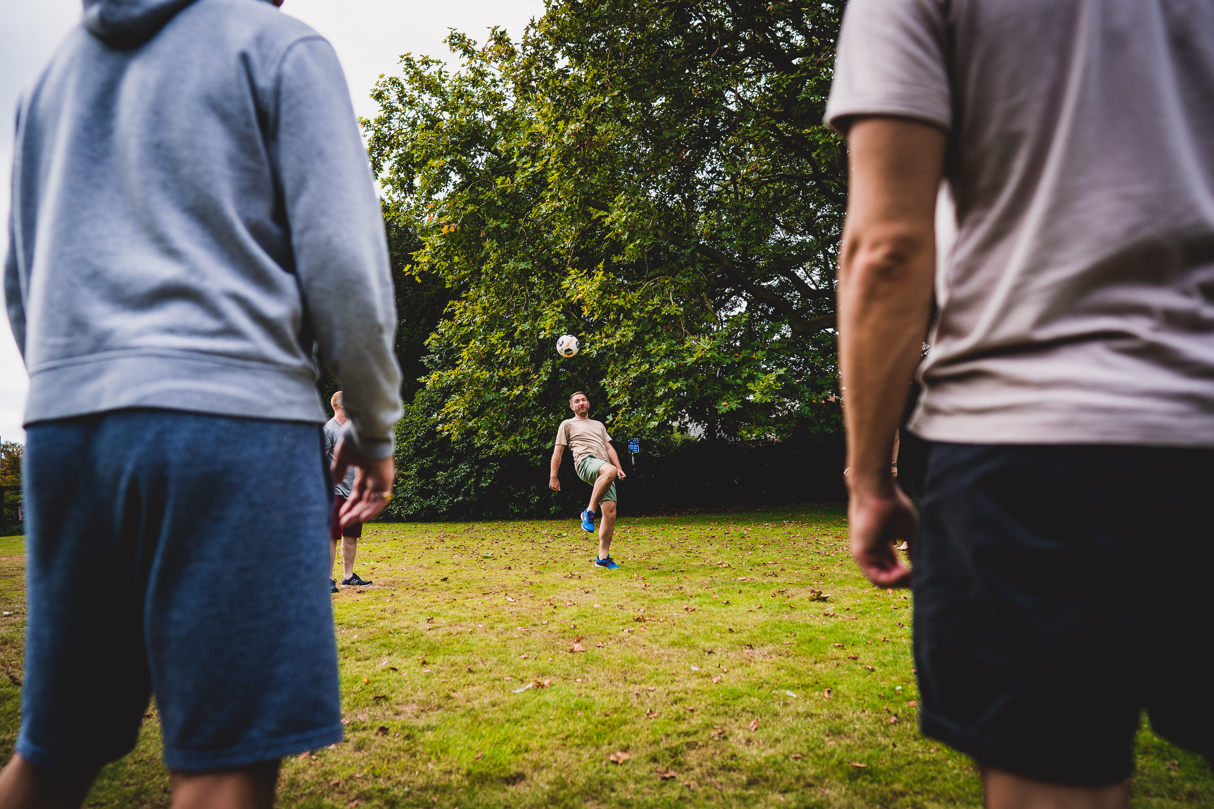 A group of people playing frisbee during a wedding reception captured by a wedding photographer.