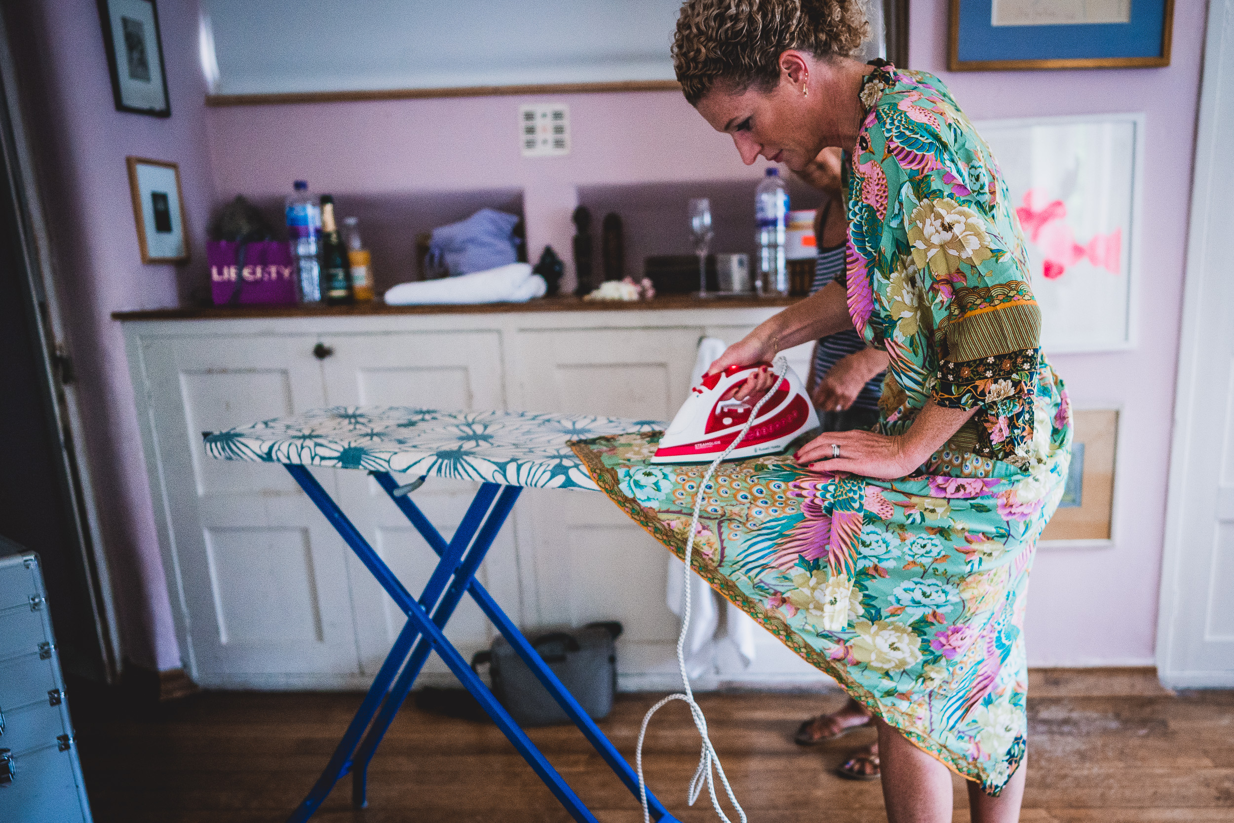 A bride ironing her gown on a wedding day.