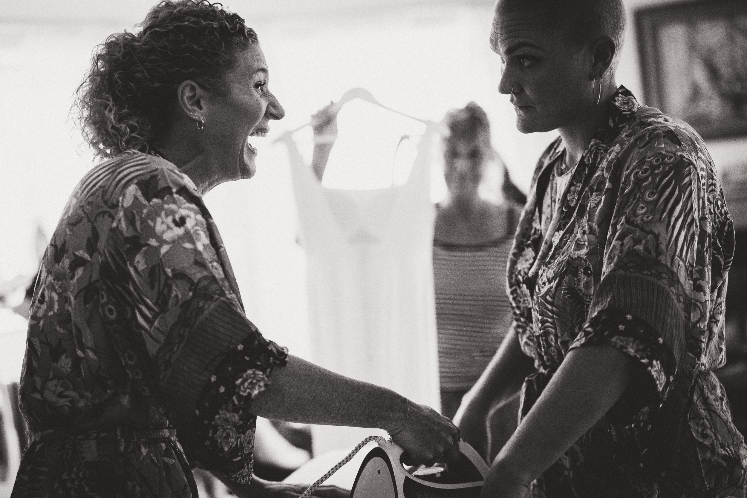 A bride and groom are getting ready in a black and white wedding photo.