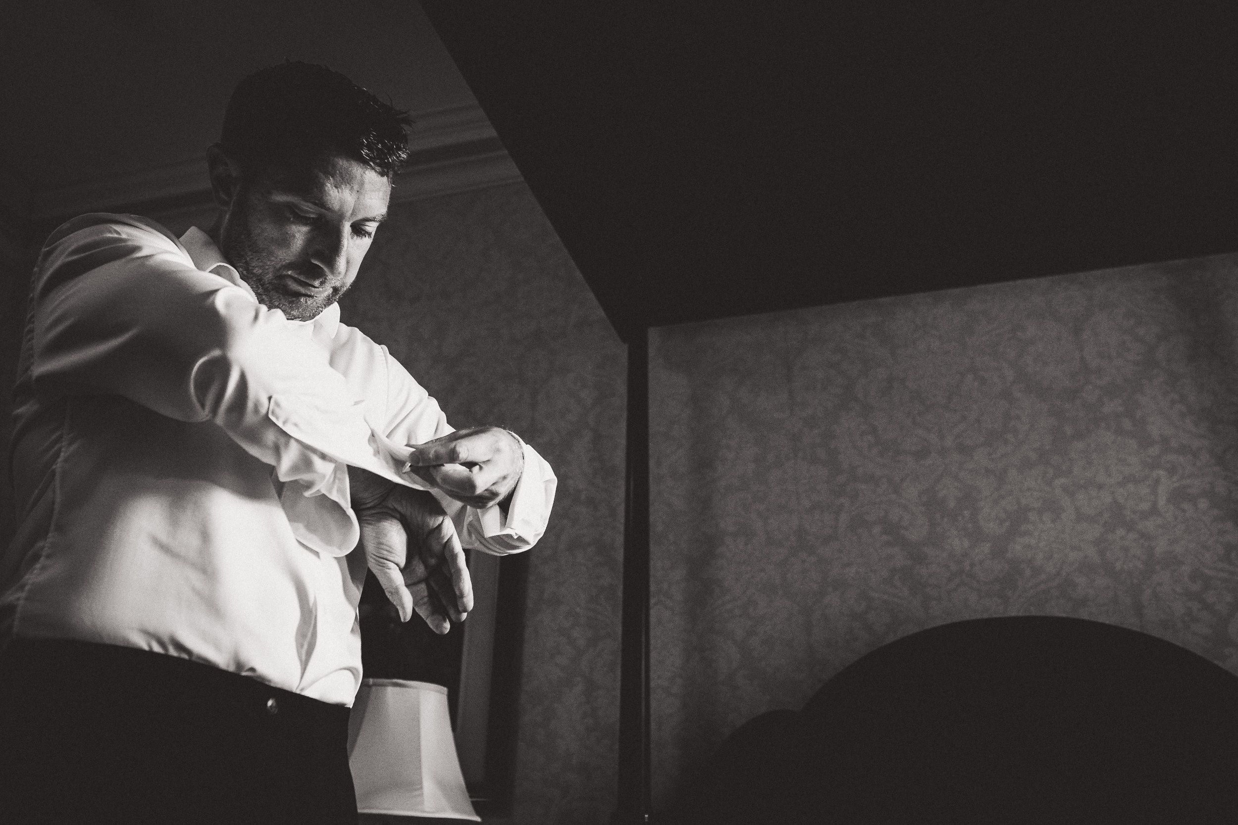 A groom adjusting his watch.