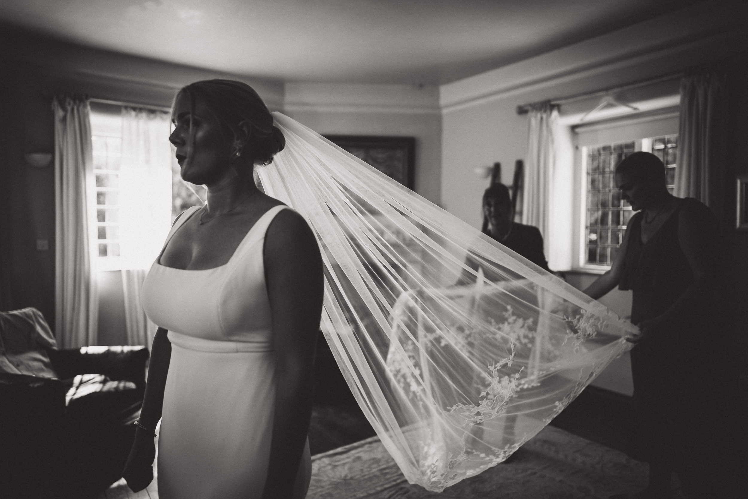 A bride is posing in front of a mirror wearing her wedding dress, capturing a precious moment for her wedding photo.