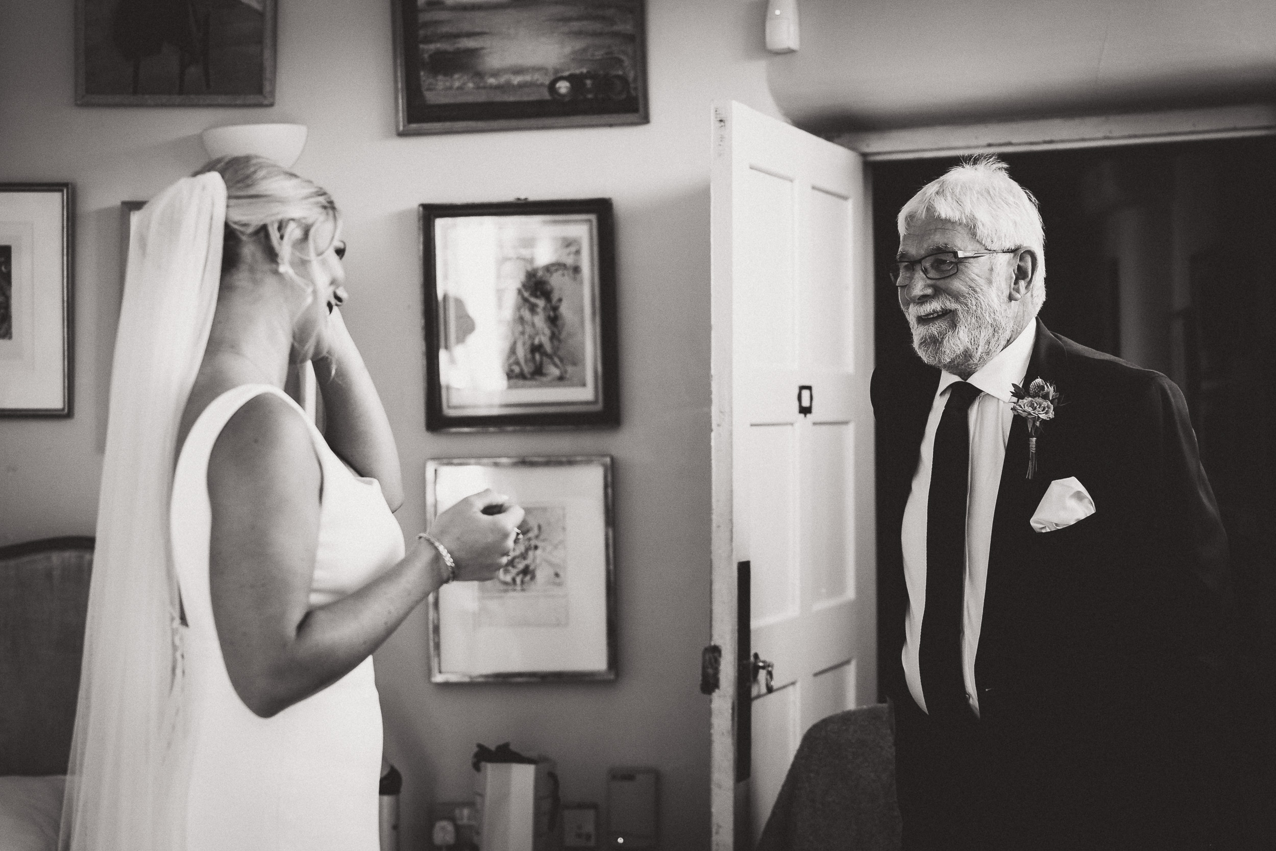 A wedding photographer captures a groom and bride sharing an intimate gaze before a mirror.