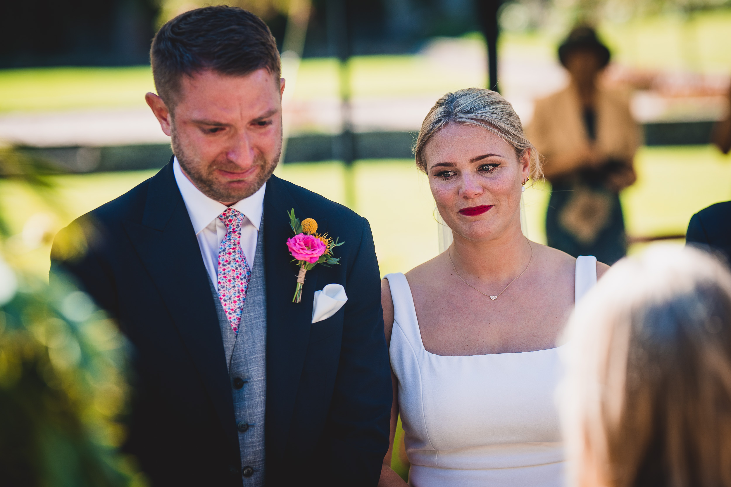 A bride and groom exchange glances during their wedding ceremony.