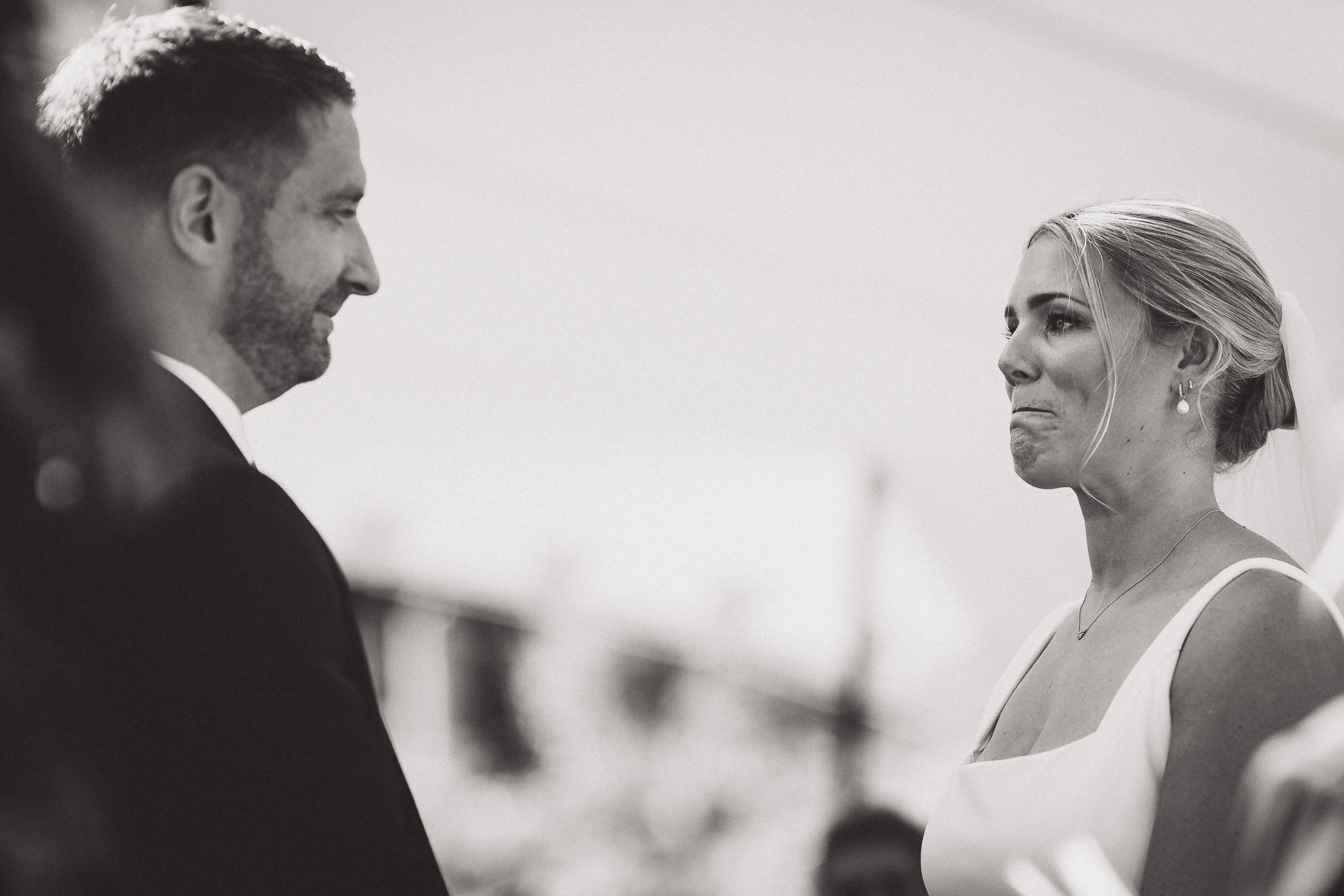 A bride and groom share a tender moment during their wedding ceremony, captured by a wedding photographer.