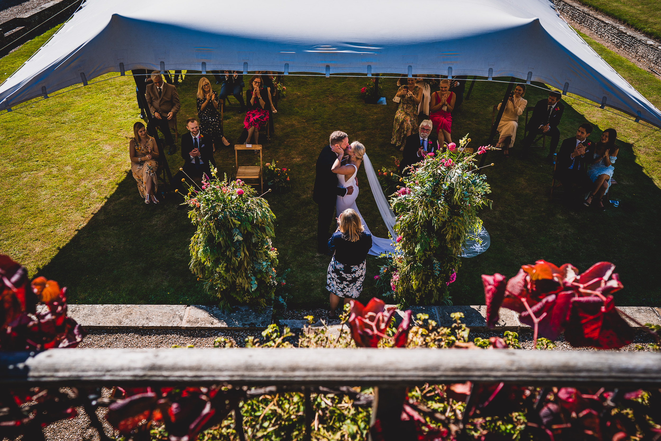 A garden wedding ceremony with a tent where the groom and guests gather for a memorable day.